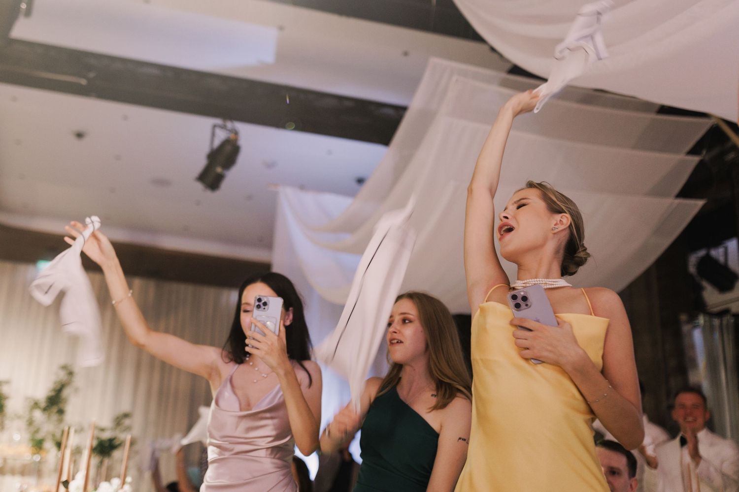 Joyful wedding guests dancing and celebrating at a lively reception party.