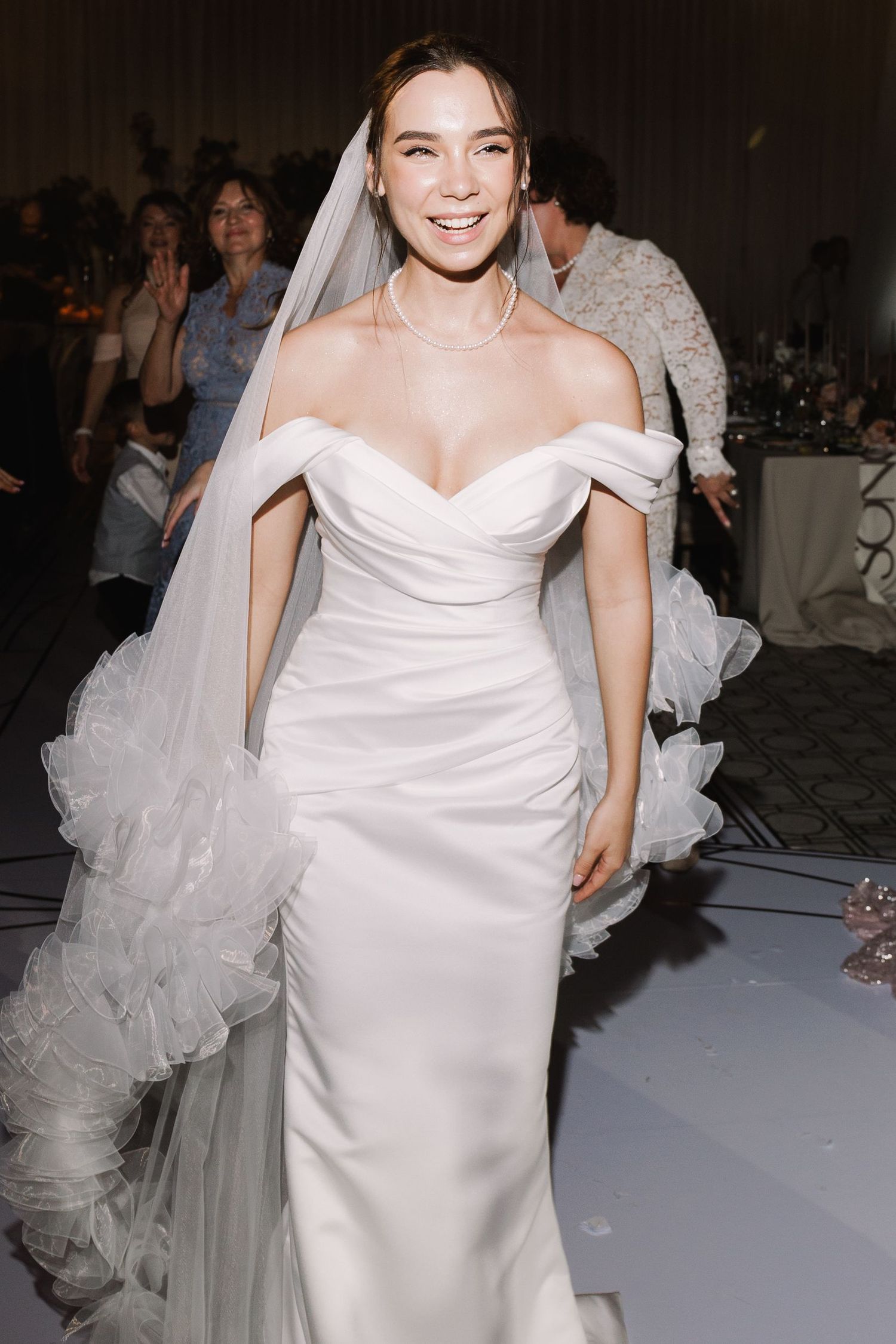 Elegant white wedding dress with off-shoulder neckline and fitted silhouette.