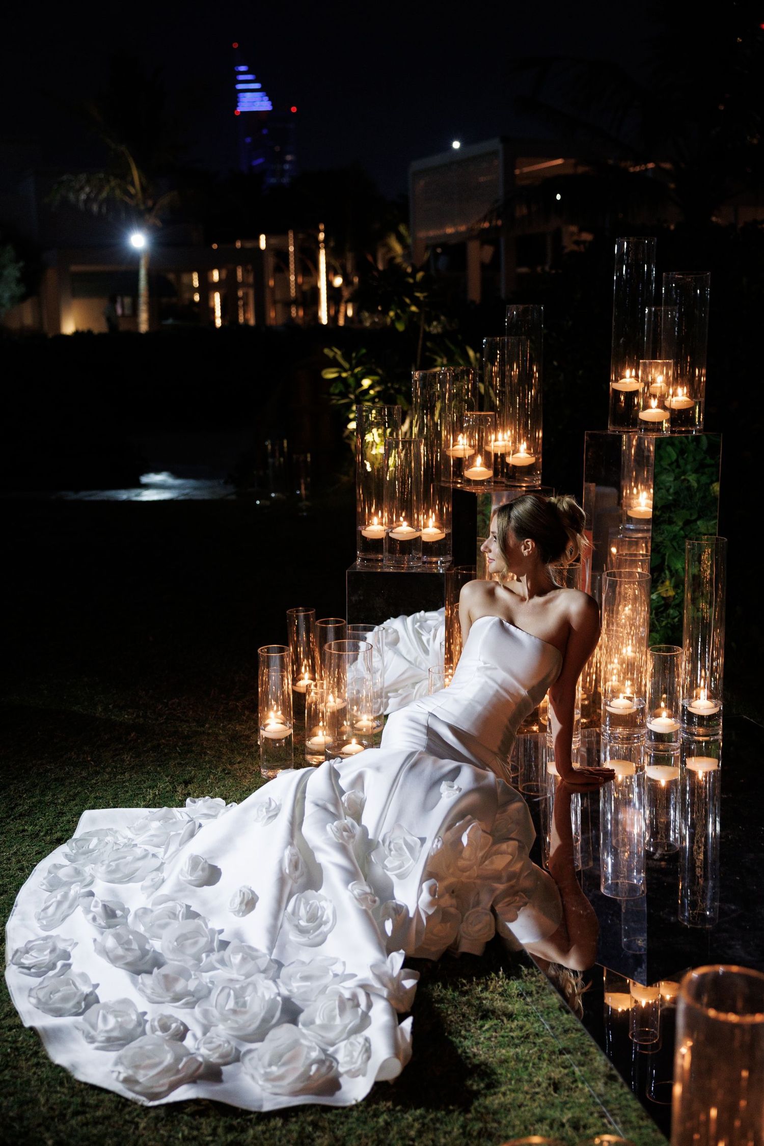Romantic candlelit scene with flowing white dress against dark background.