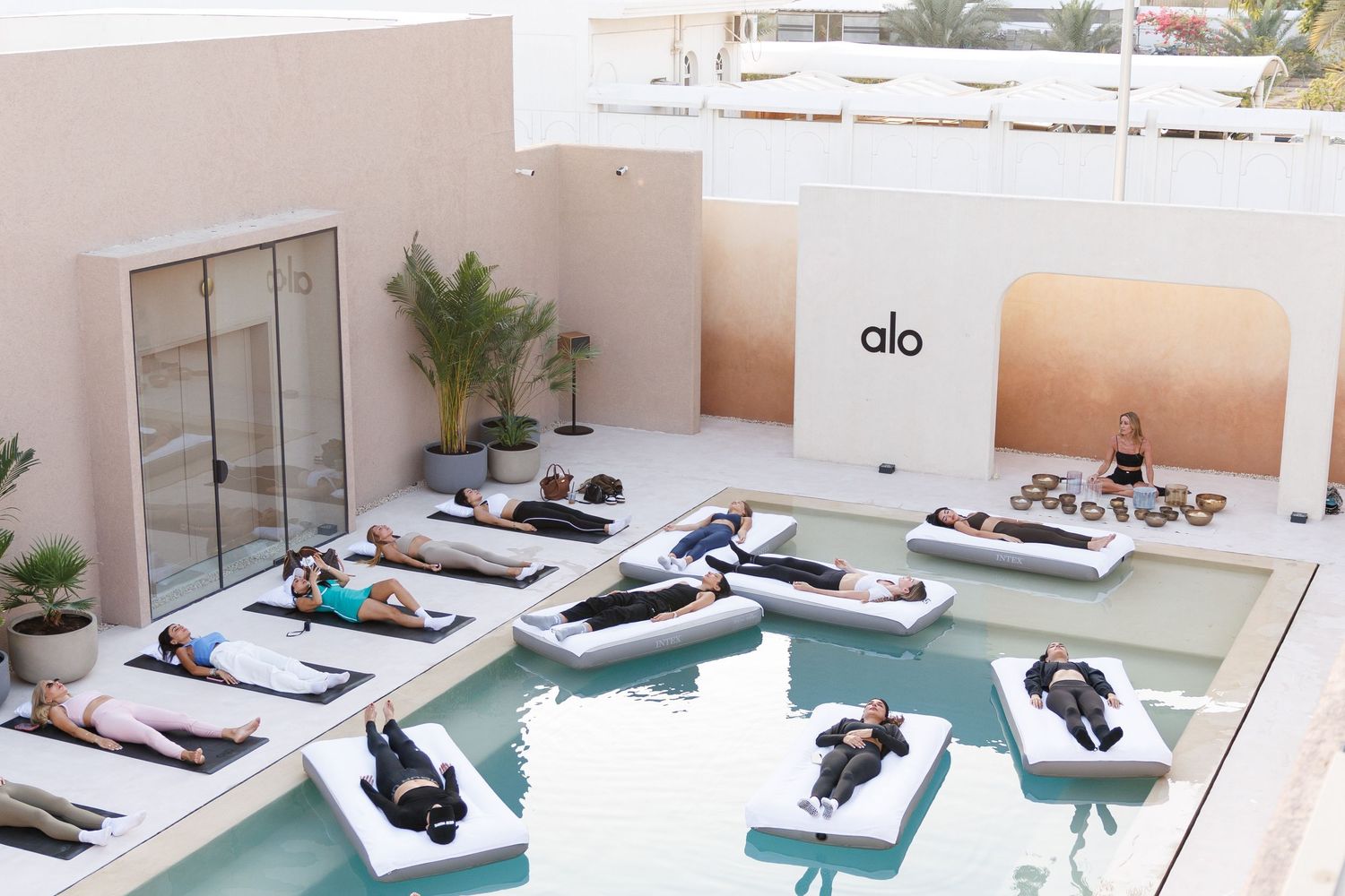 Outdoor pool area with white lounge chairs arranged along a modern patio space.
