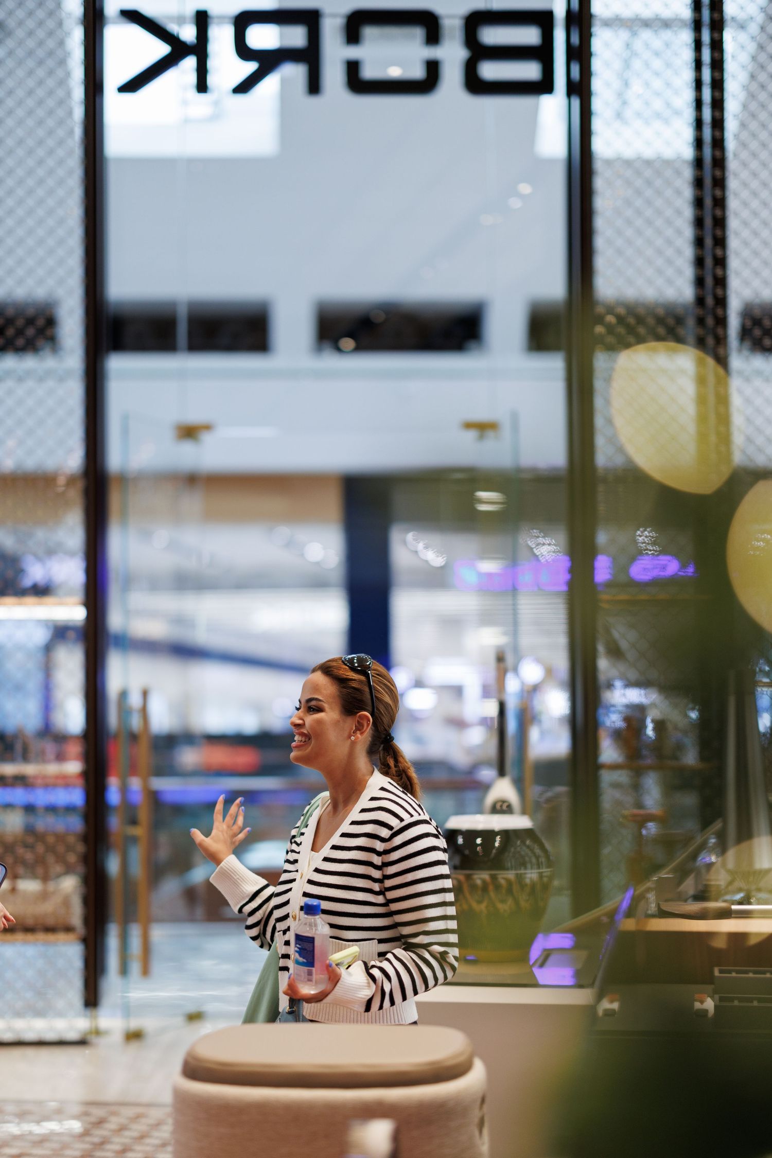 Person in striped shirt relaxing in modern cafe seating area with BORK branding visible.
