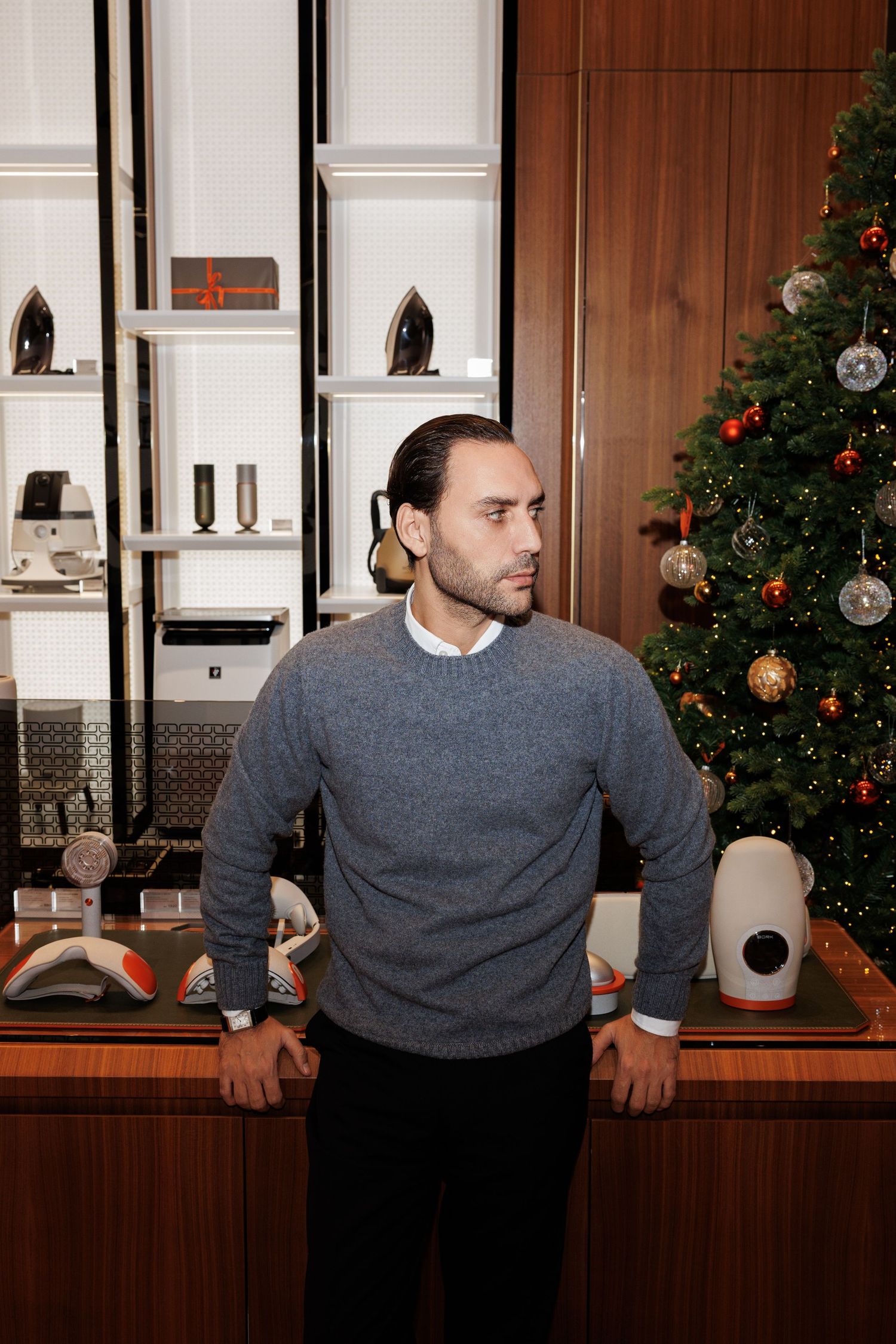 Modern kitchen interior with wood paneling and decorated Christmas tree.