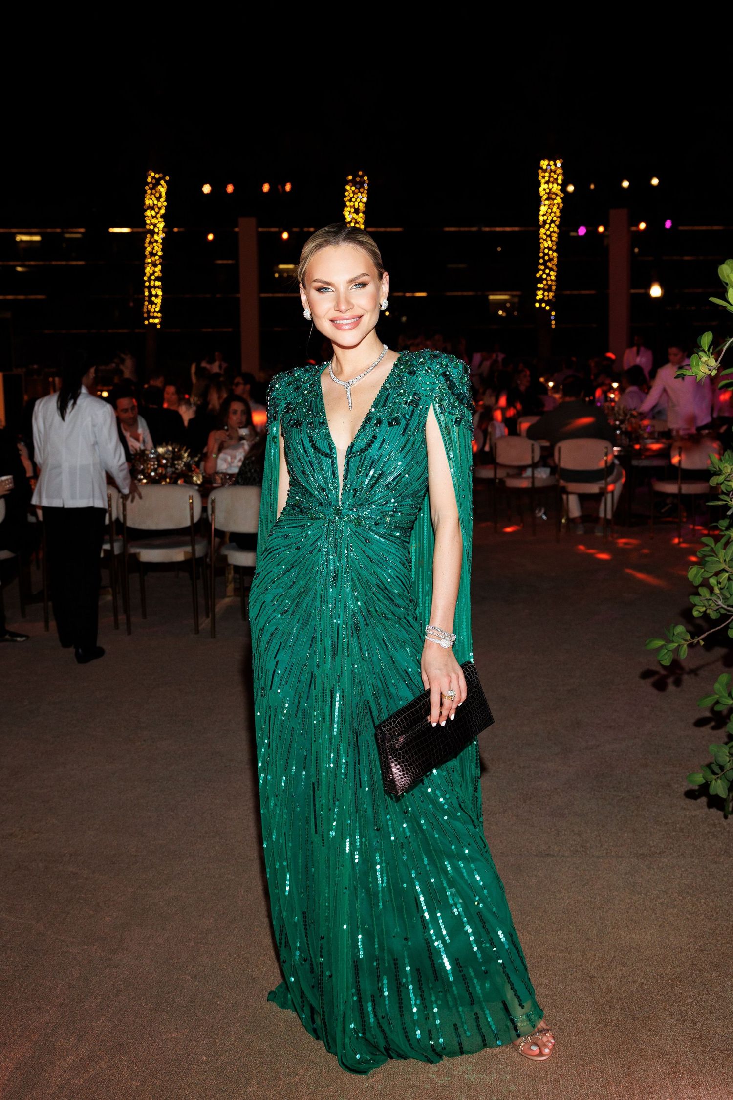 Glamorous event setting with a guest in a sparkling emerald green gown.
