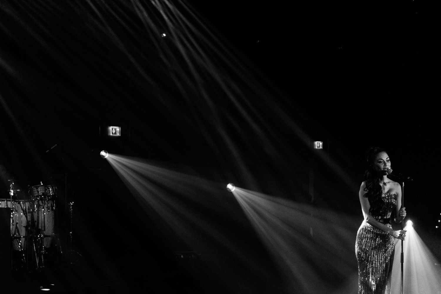Dramatic black and white stage photo with striking beam lighting effects.