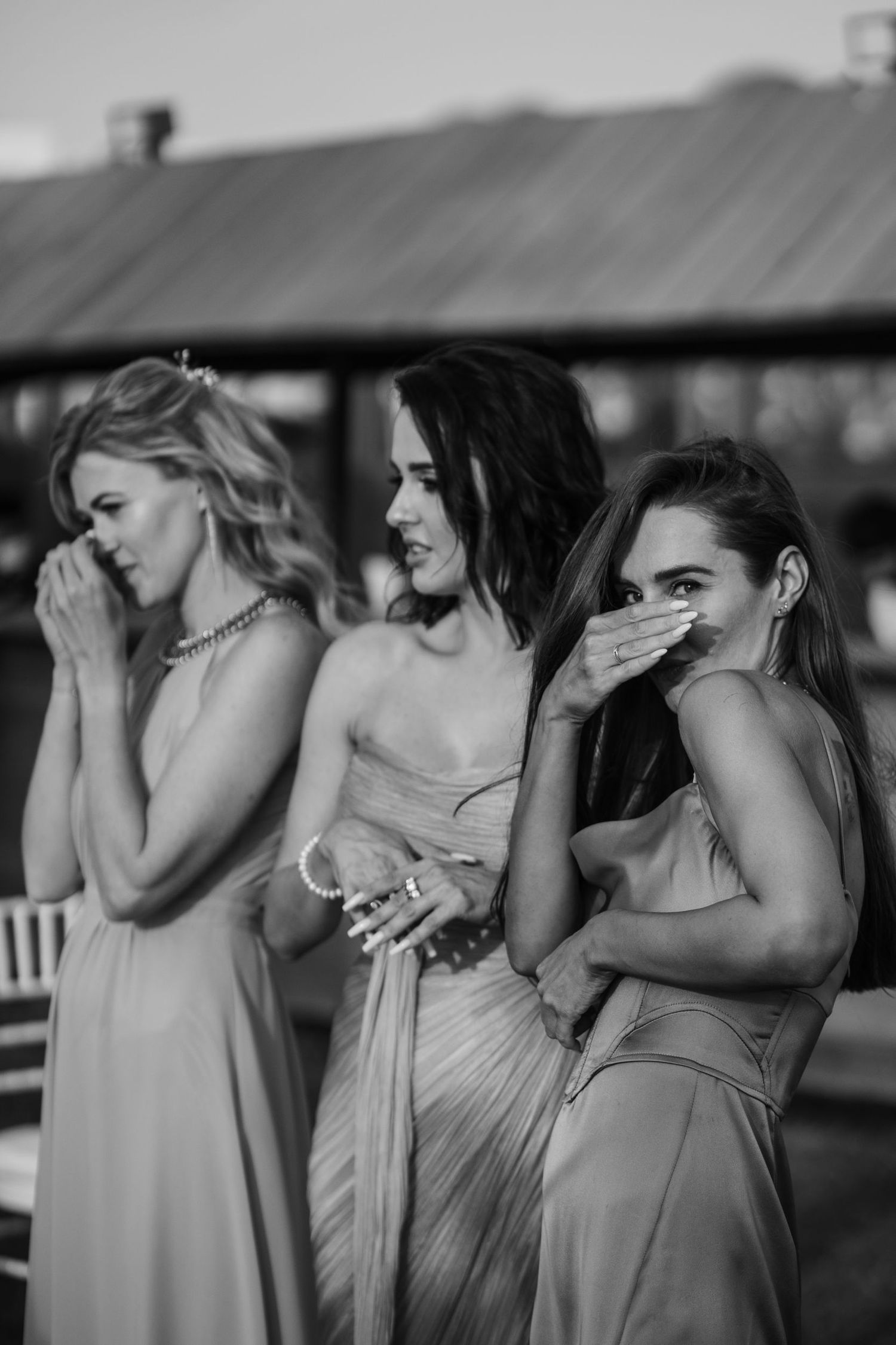 Bridesmaids in matching dresses showing emotional reactions during a wedding ceremony.