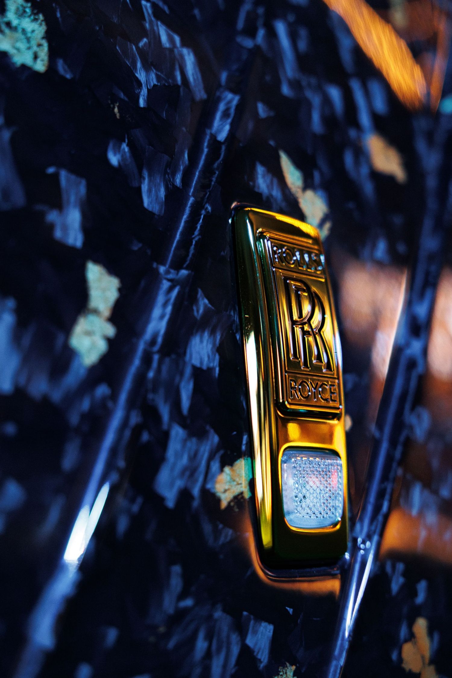 Gold perfume bottles with Arabic text displayed against dark blue background.