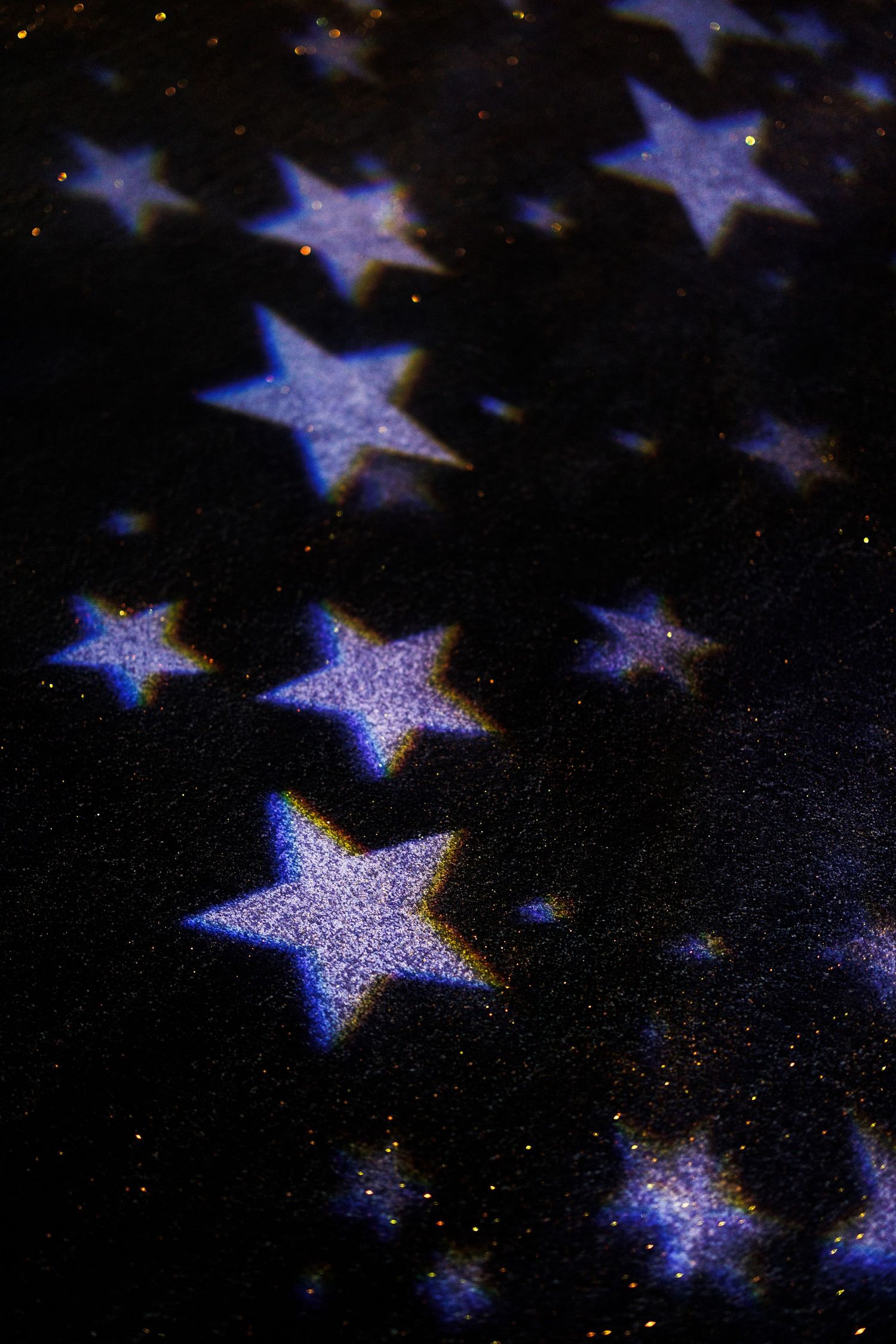 A pattern of glowing blue and white stars against a dark background creates an ethereal celestial design.