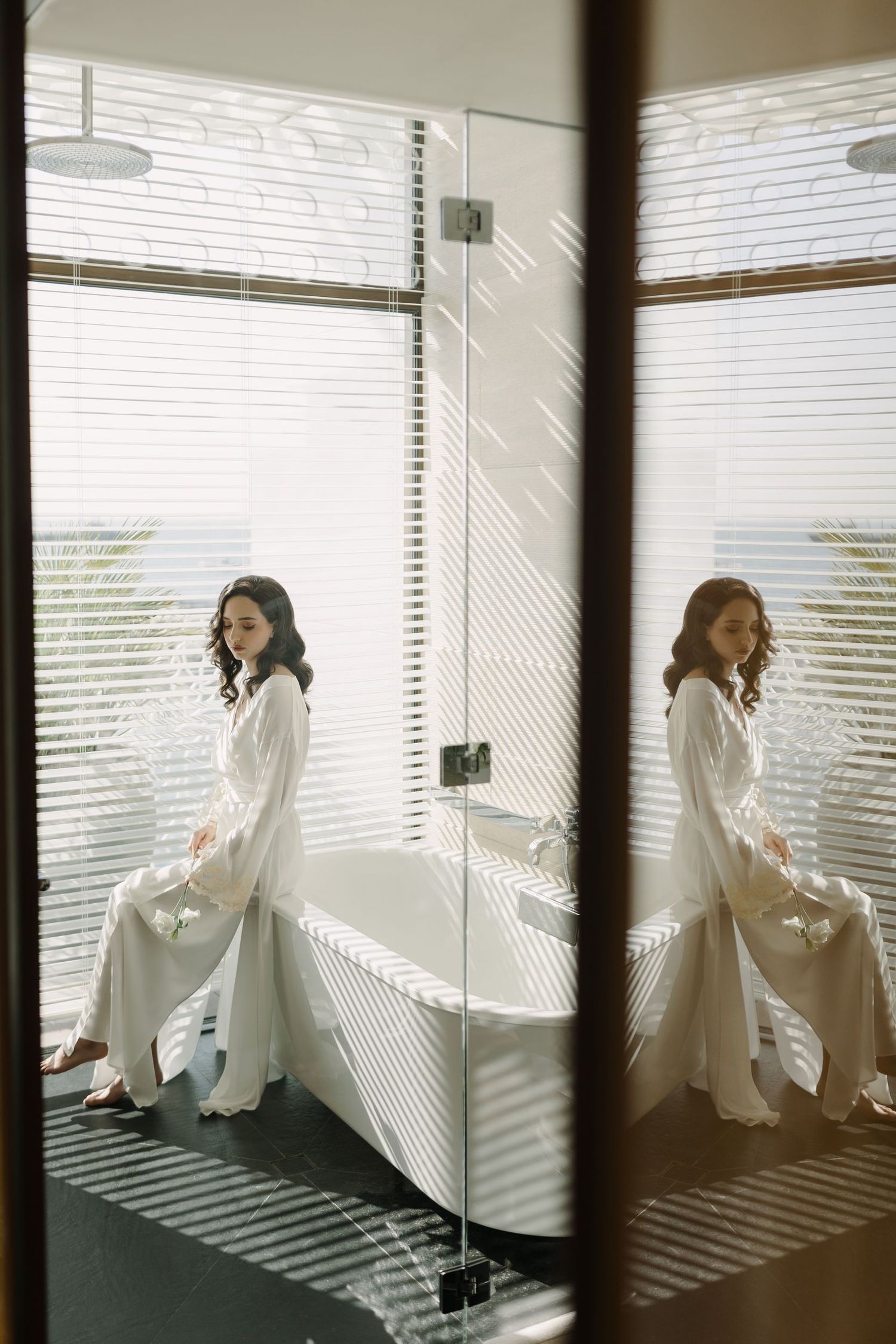 Artistic sequence of a person in white by a window with venetian blind shadows.