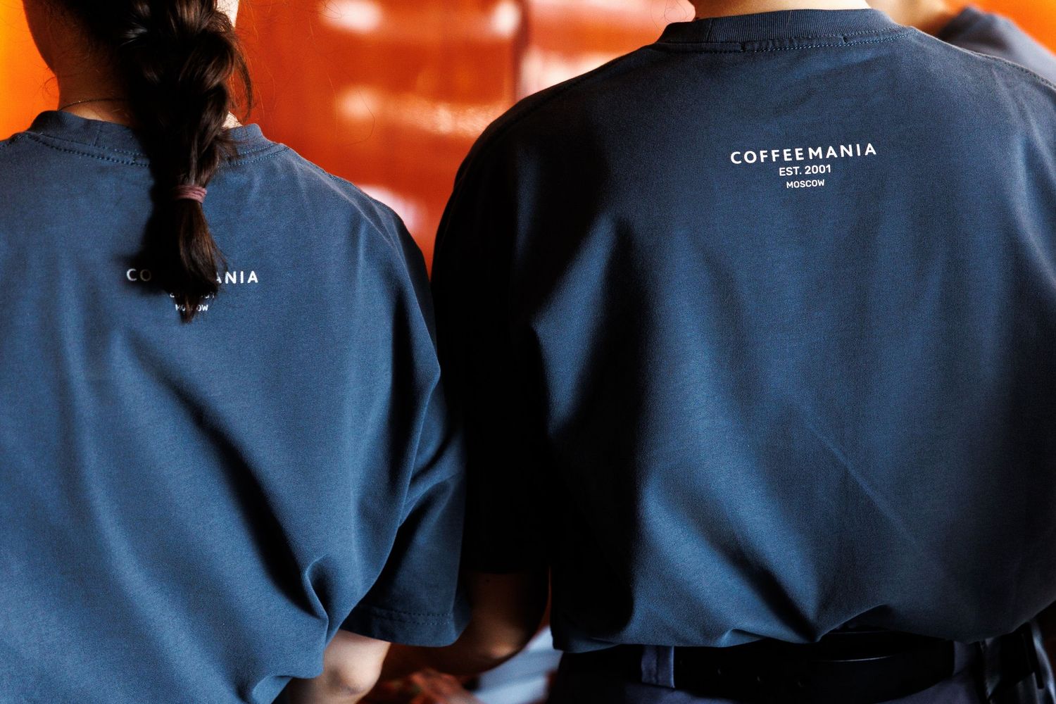 Staff members wearing blue uniforms at Coffeemania cafe.