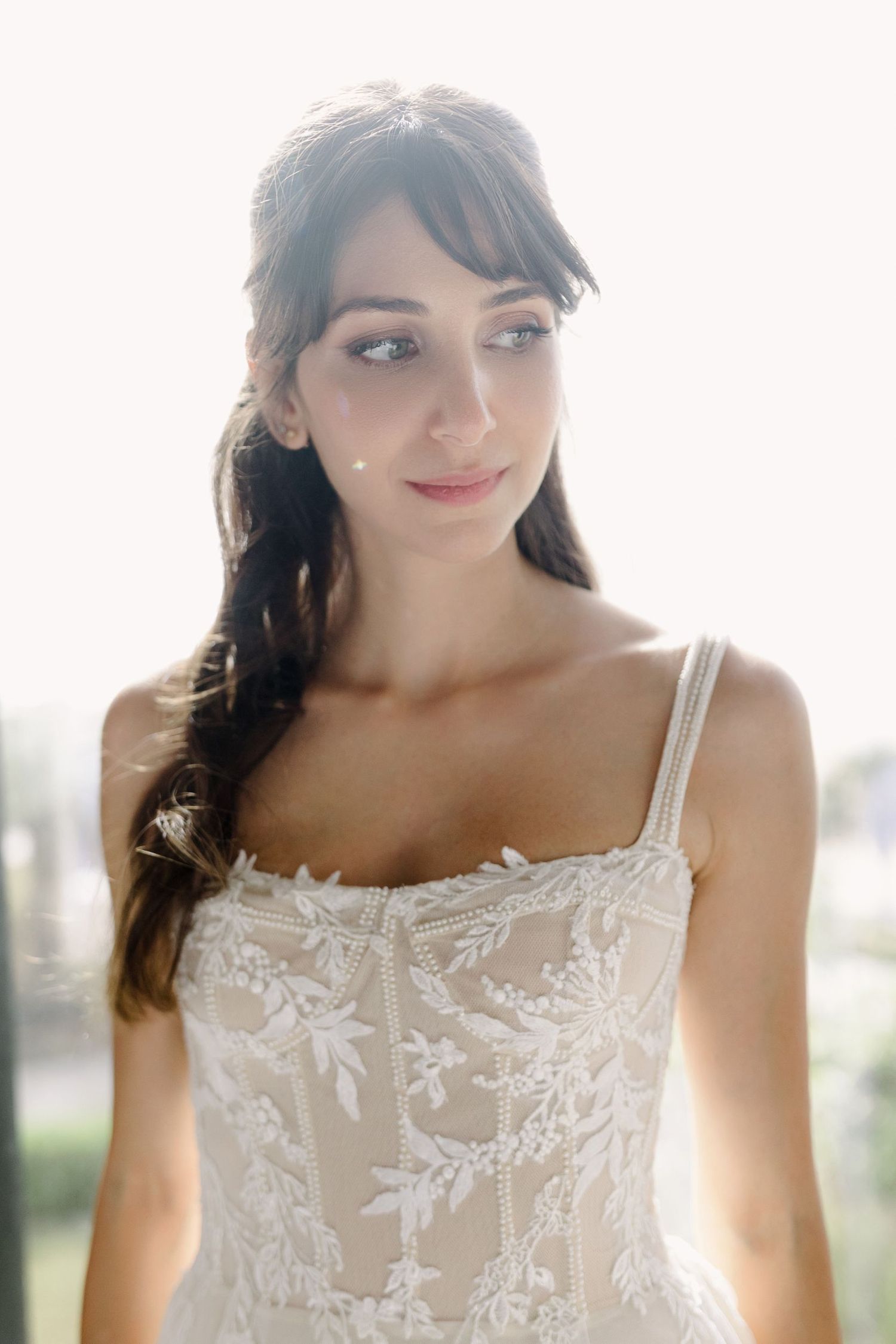 Delicate white lace wedding dress with intricate floral embroidery details.