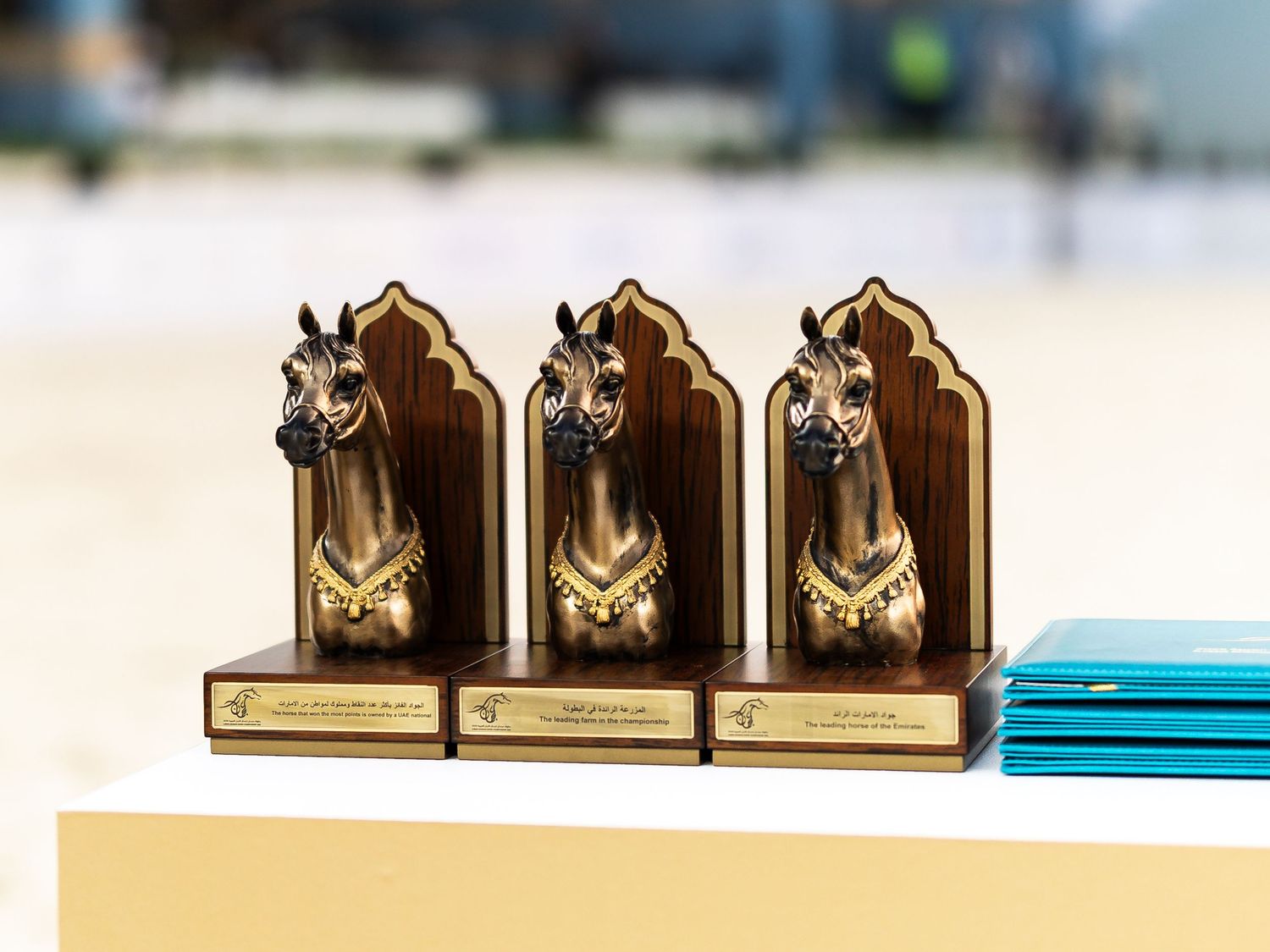 Three identical bronze horse head bookends with decorative details displayed in a row on a surface.