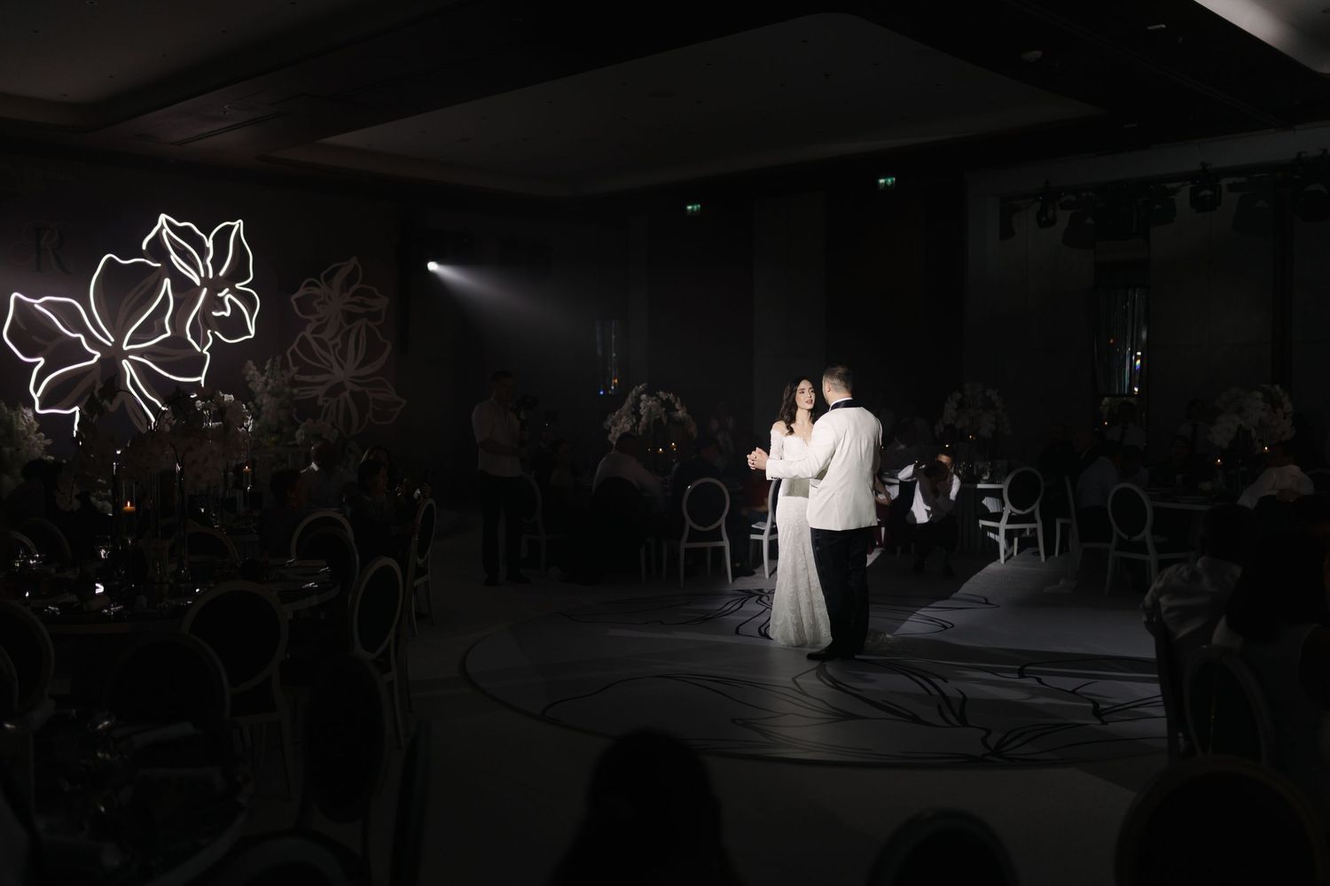 Wedding reception venue illuminated with dramatic lighting and elegant decor.