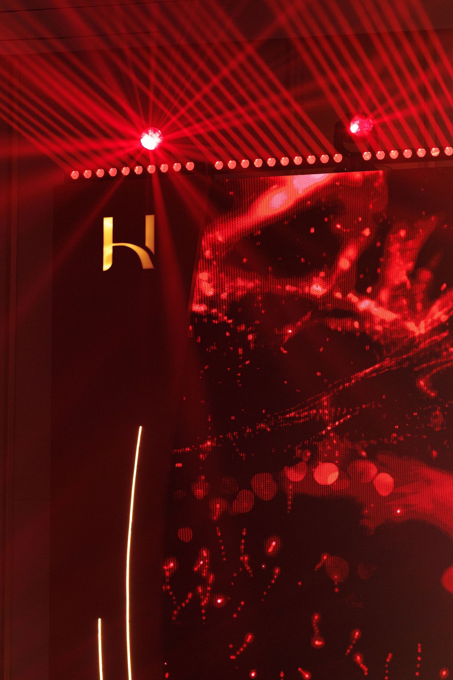 Abstract red lighting effects with laser beams creating dynamic patterns.