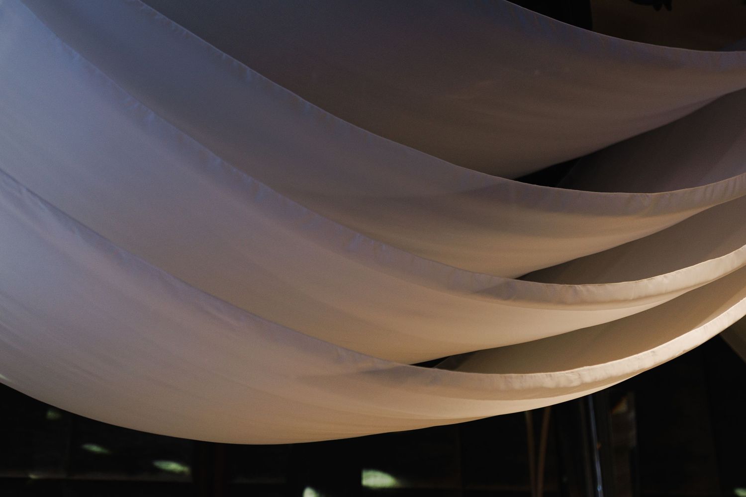 Elegant white fabric draping creates a romantic ceiling treatment at an event venue.