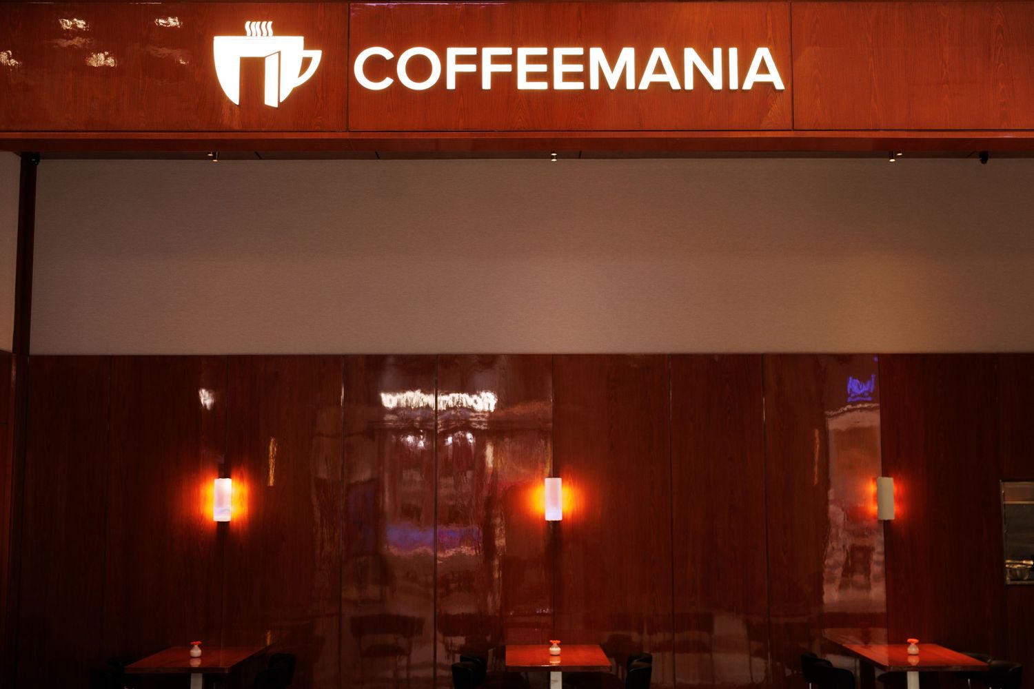 Coffeemania restaurant sign illuminated in red against a dark background.