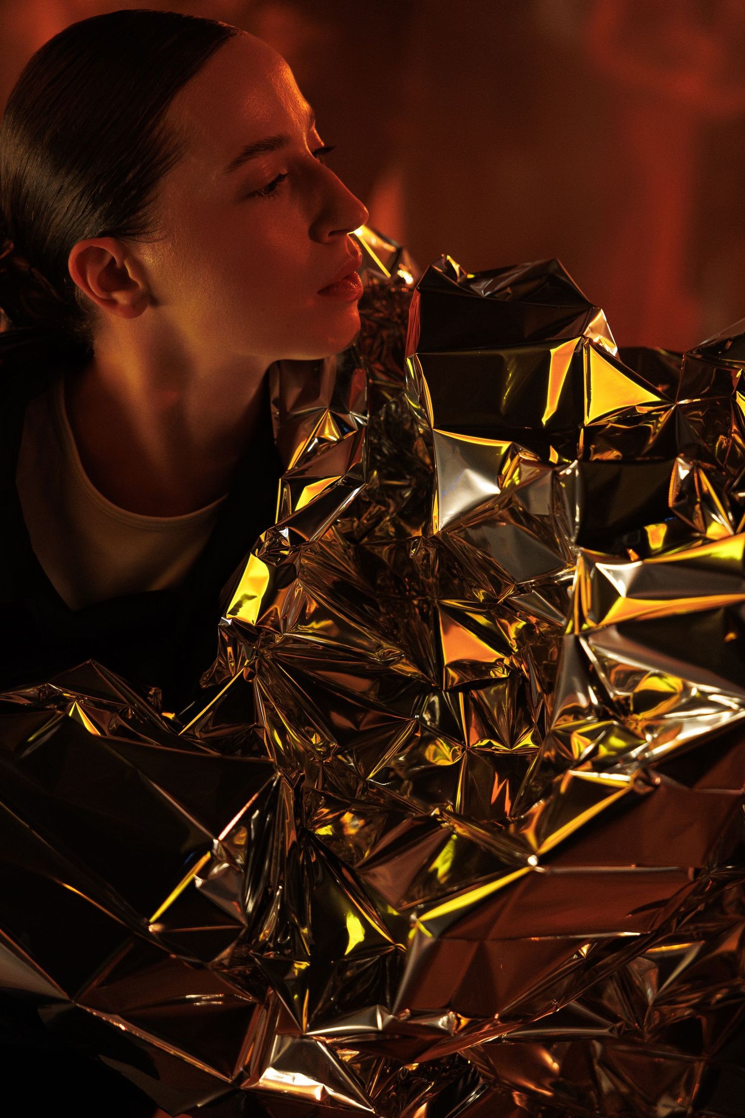 Reflective metallic surface creating abstract geometric patterns in golden lighting.