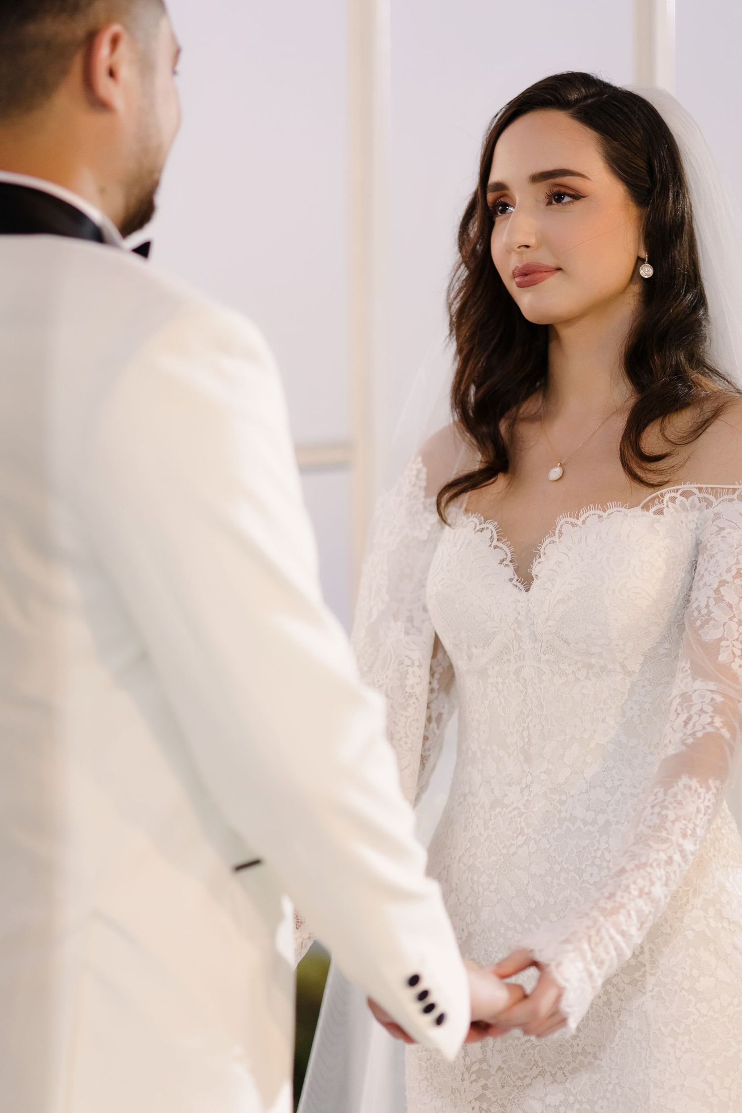 Elegant wedding ceremony moment with white decor and formal attire.