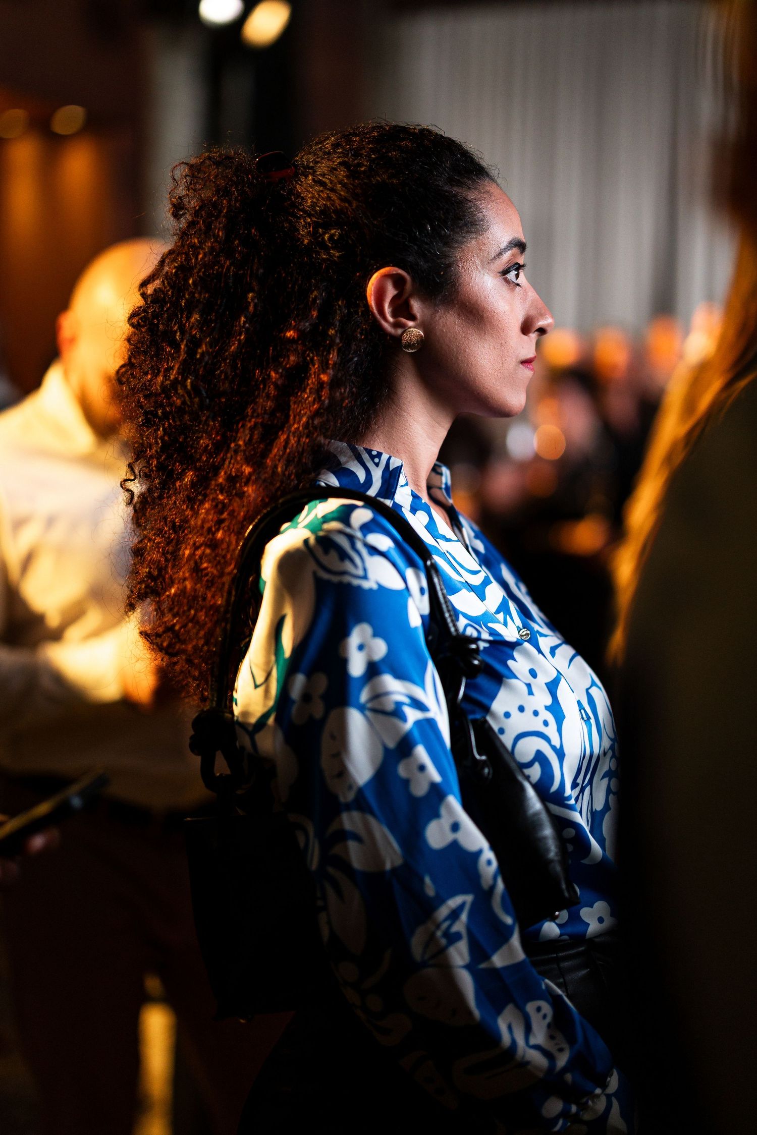 A figure with curly hair wearing a blue and white patterned top shown in a sequence of side profile shots.