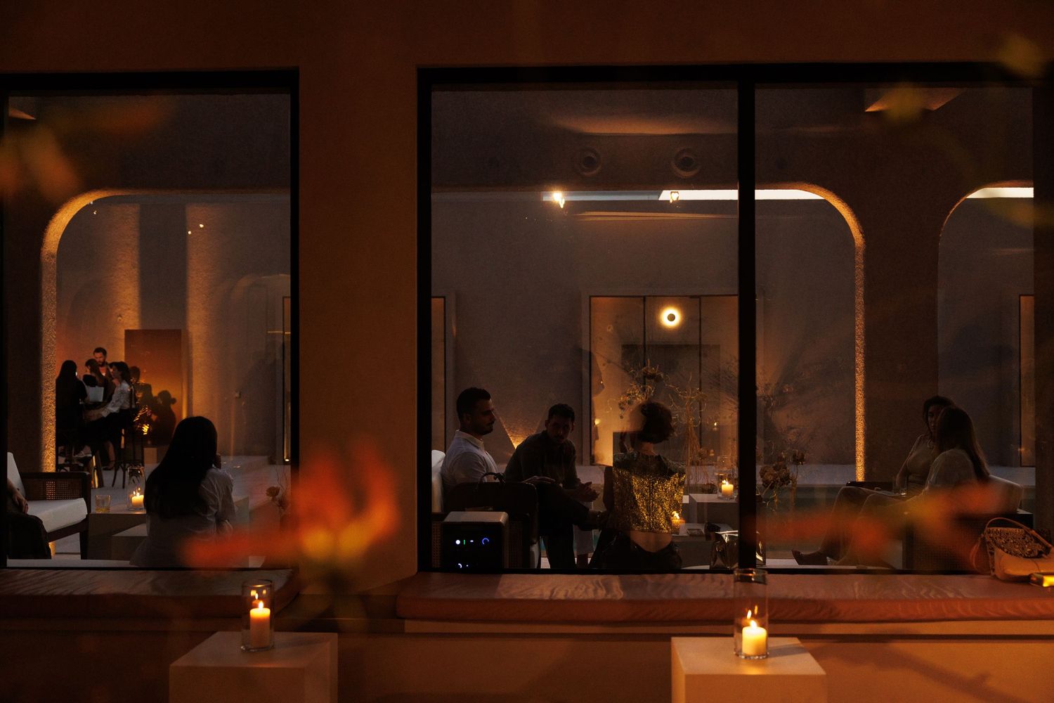 Dimly lit interior space with warm ambient lighting and silhouetted figures.