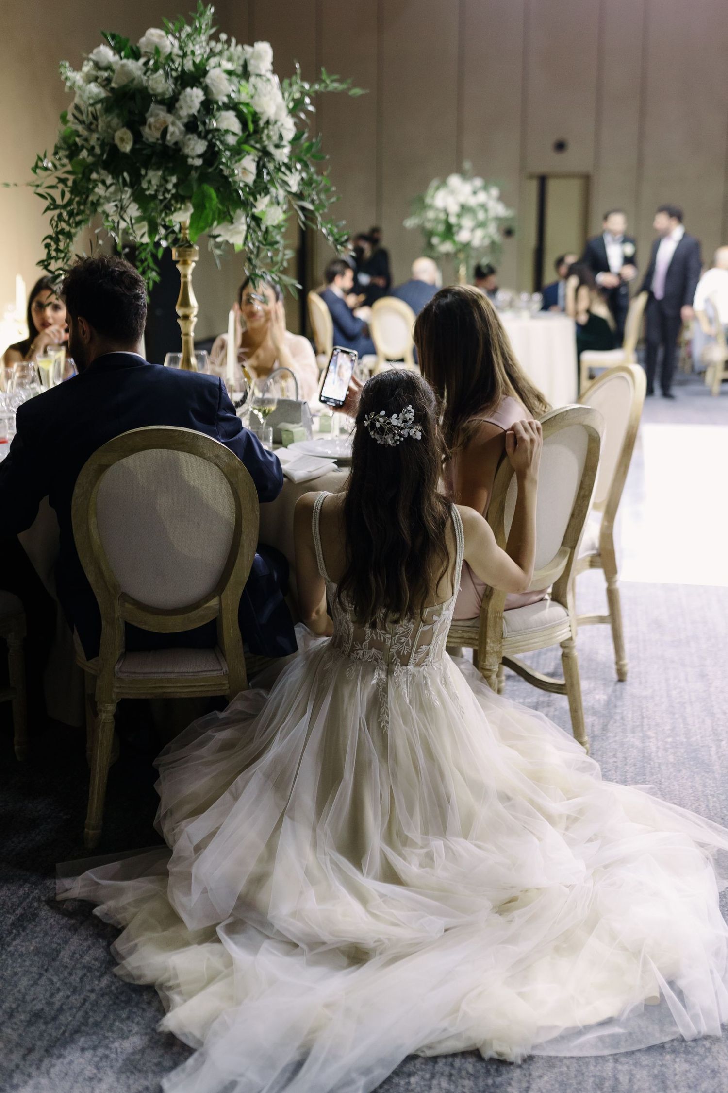 Wedding reception dinner scene with elegant floral centerpieces and formal table settings.