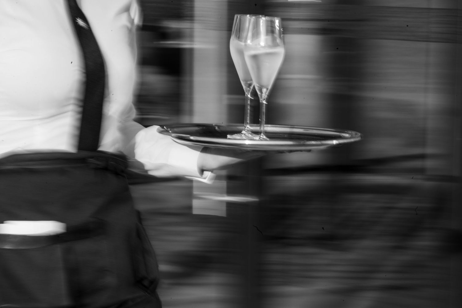 Black and white image of elegant table settings and wine glasses at a wedding reception.