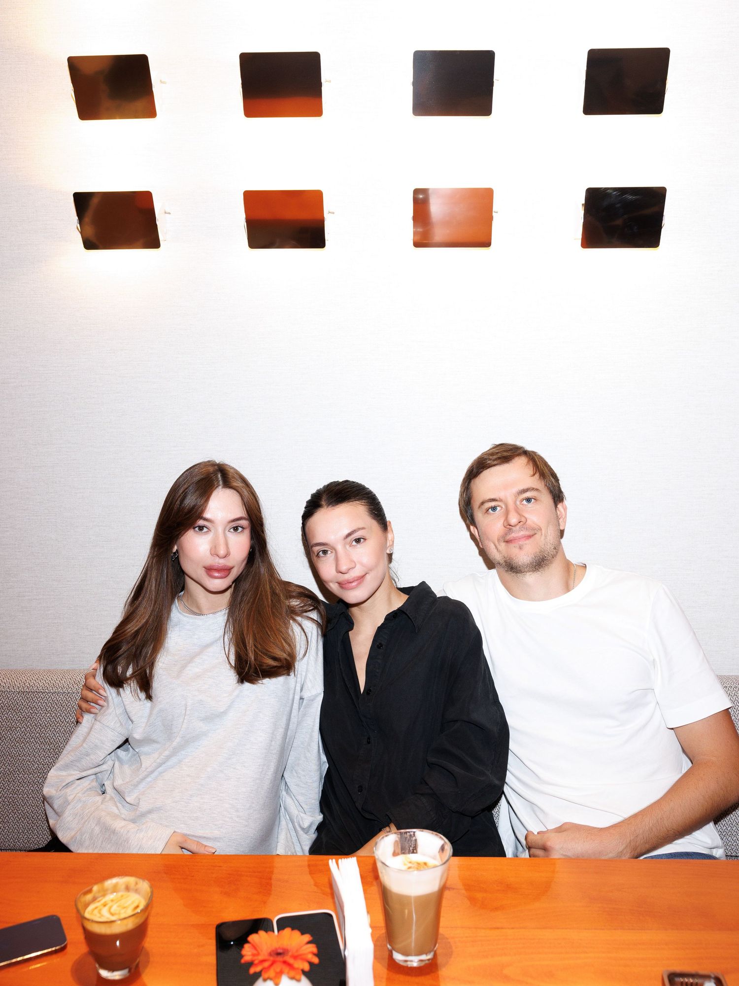 Three friends enjoying coffee and conversation at a modern cafe.