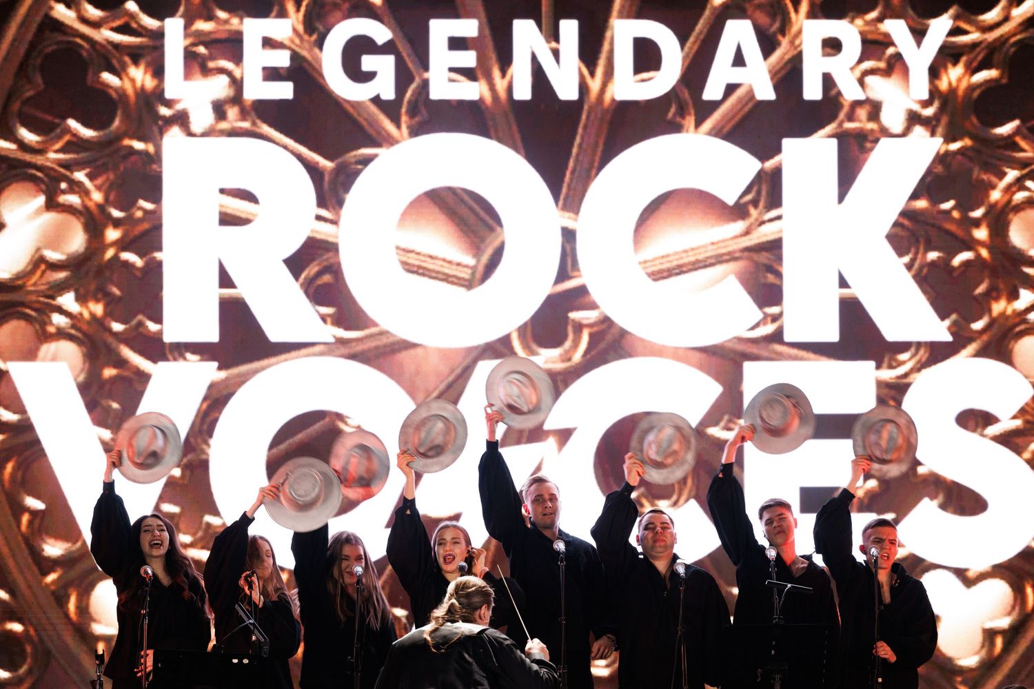 Glowing text spelling out 'LEGENDARY ROCK' with dramatic lighting effects and silhouettes in the background.