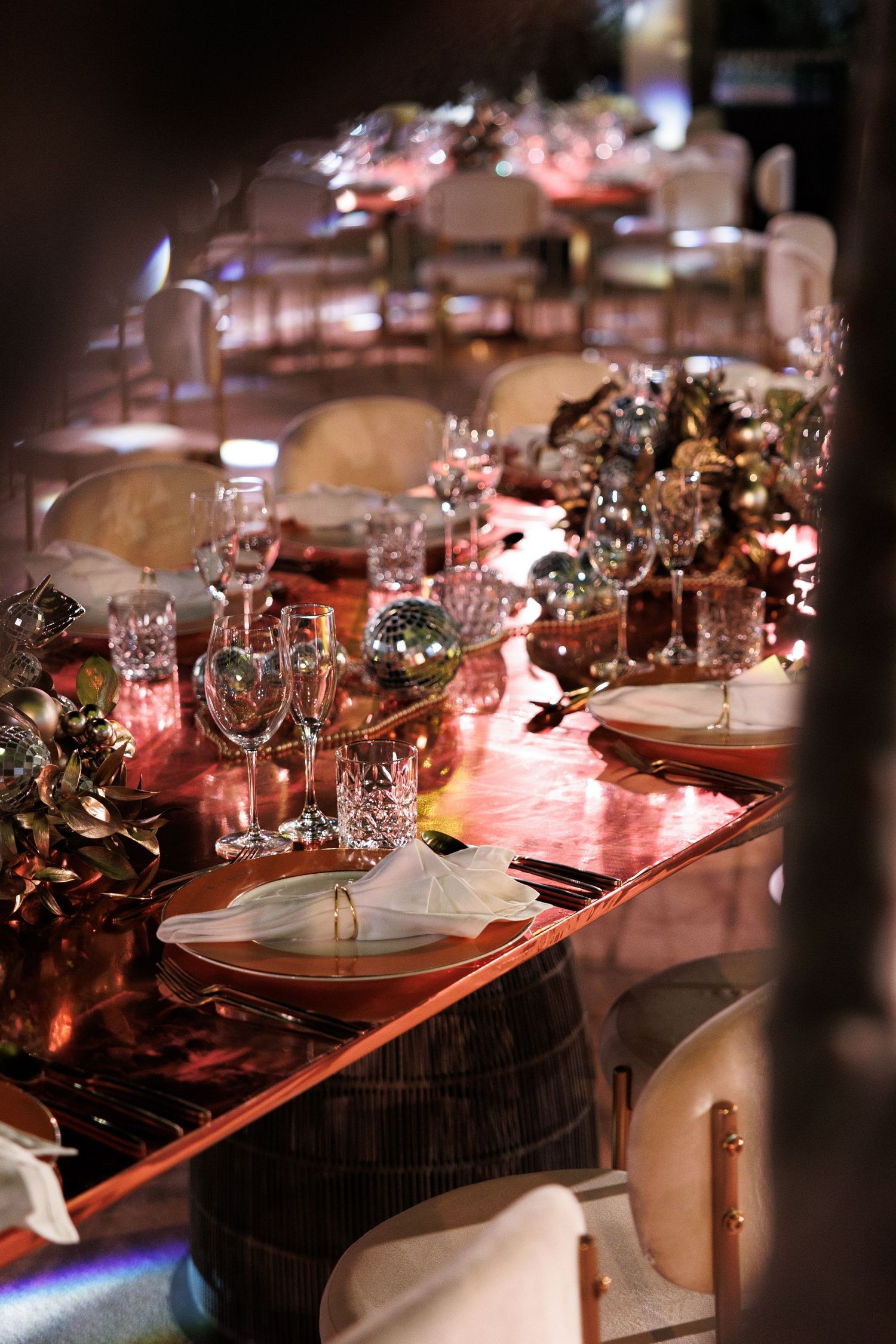 Close-up of an elegantly decorated dining table with crystal glasses and floral arrangements.
