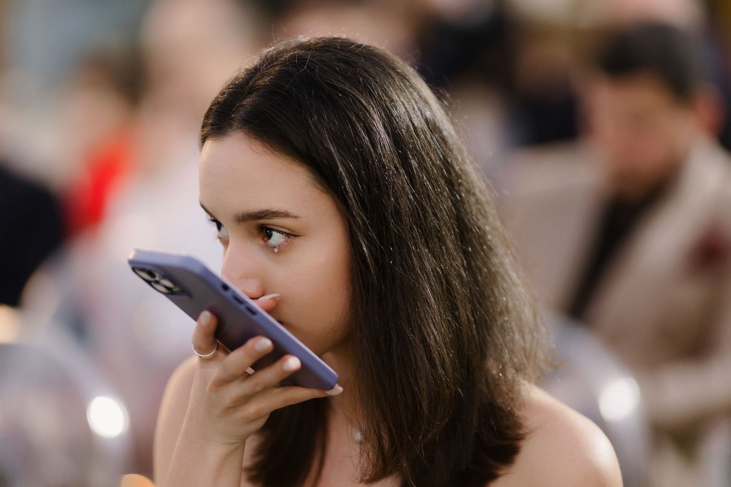 Wedding guests watching ceremony while holding phones to capture moments.