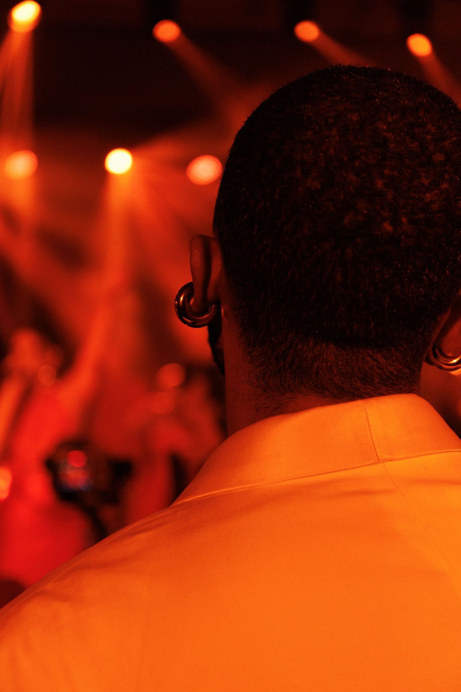 Concert stage illuminated with warm orange lighting and bokeh effects creating an atmospheric ambiance.
