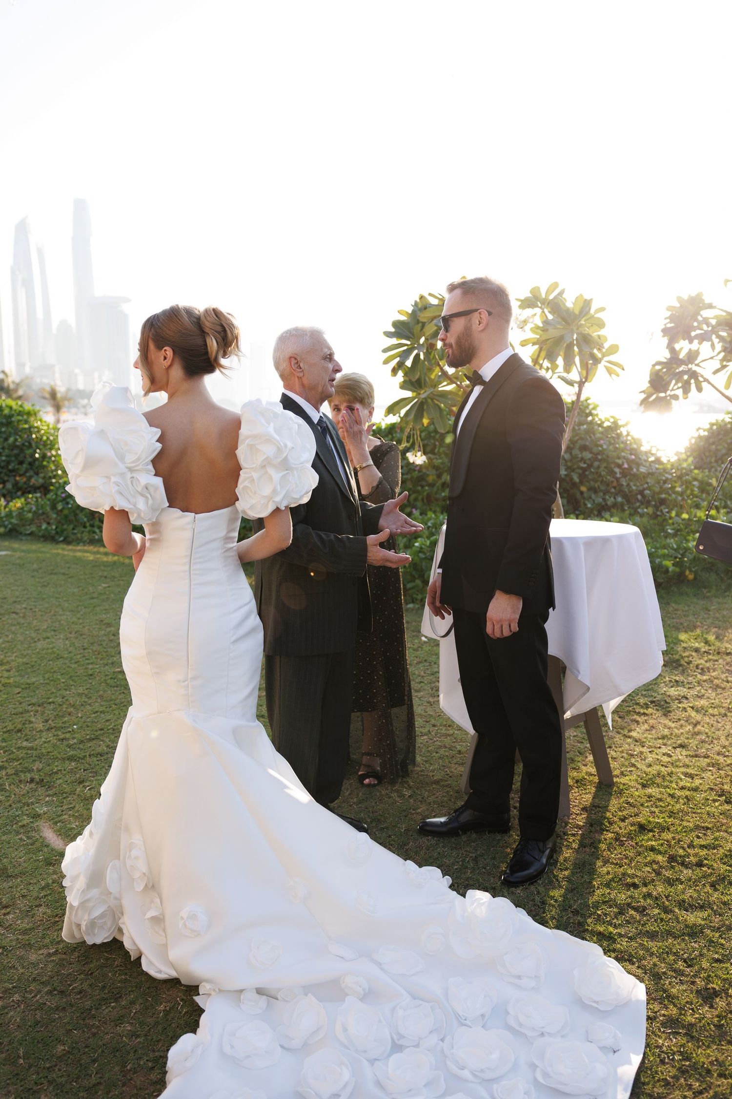 Wedding celebration in a garden setting with guests mingling during golden hour.
