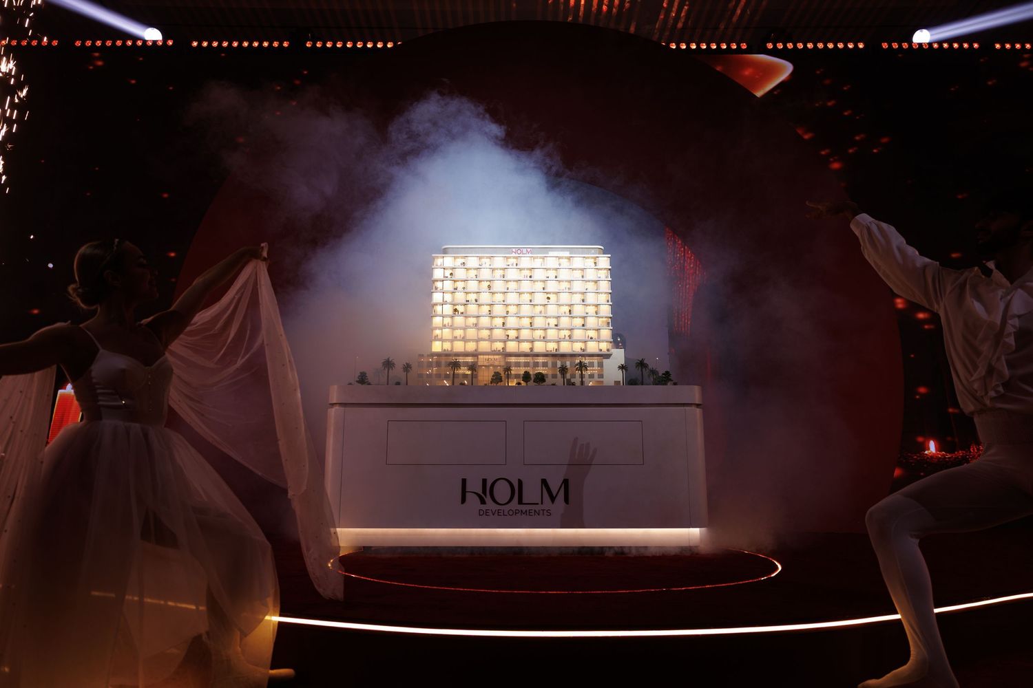 Illuminated display case with smoke effects and dramatic lighting at luxury event.
