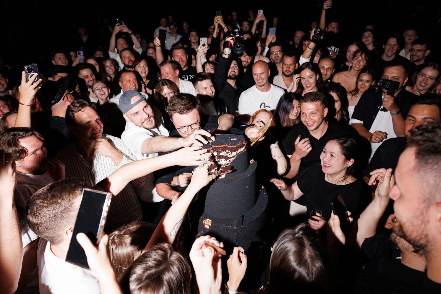 Excited crowd surrounds performers during high-energy event.
