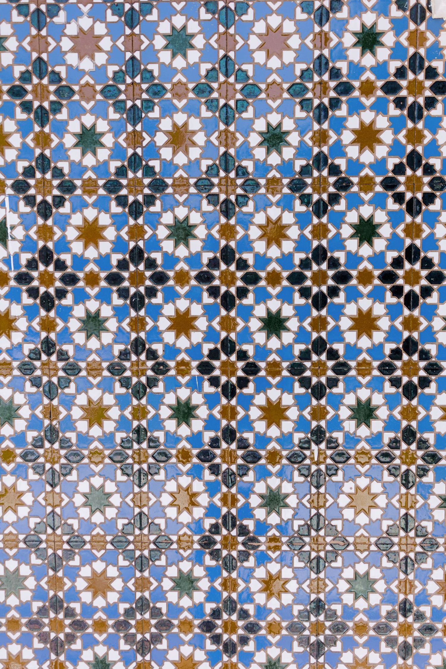 Intricate geometric Islamic pattern with blue, white and gold star motifs.