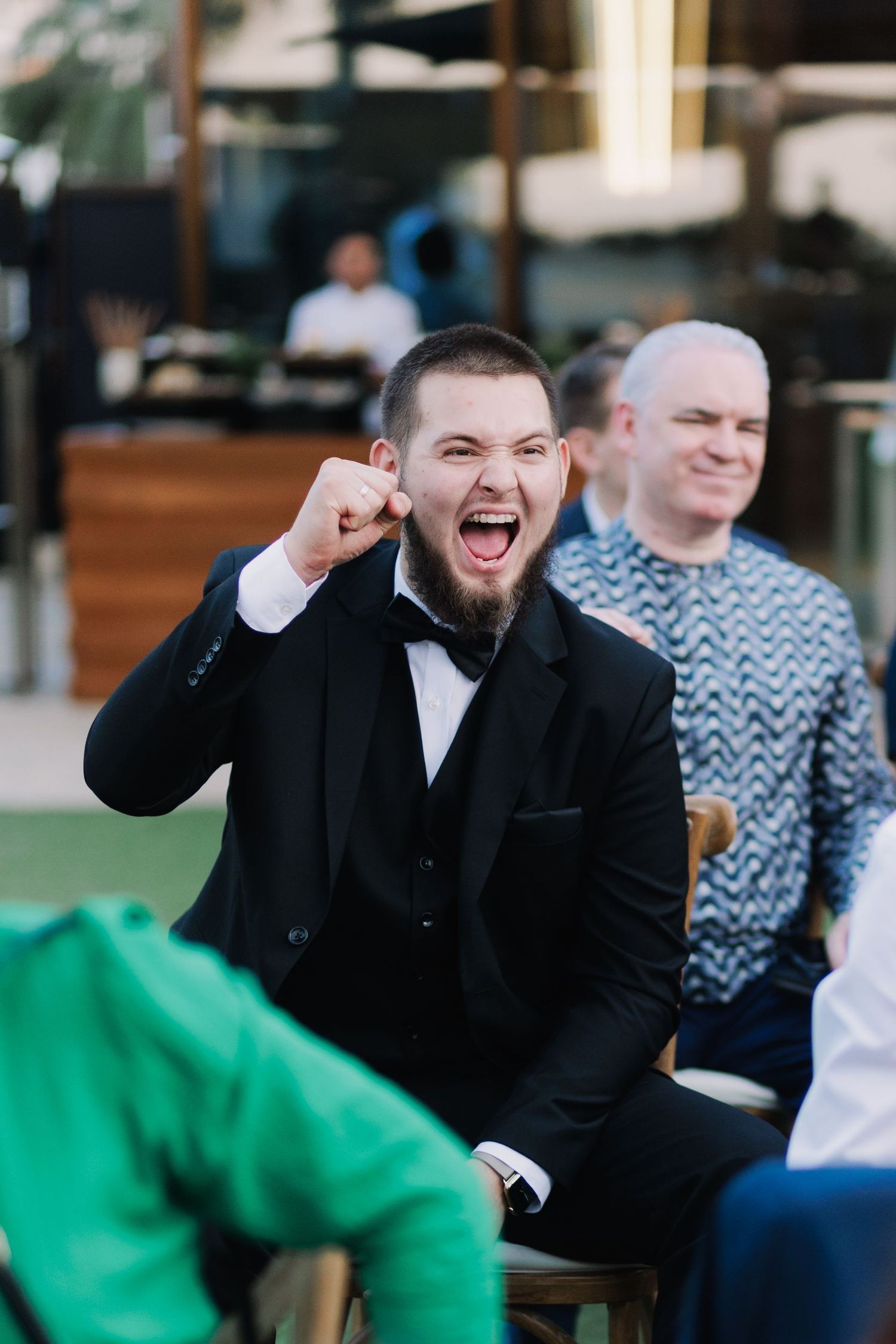 Wedding guest in formal attire showing excitement during celebration.