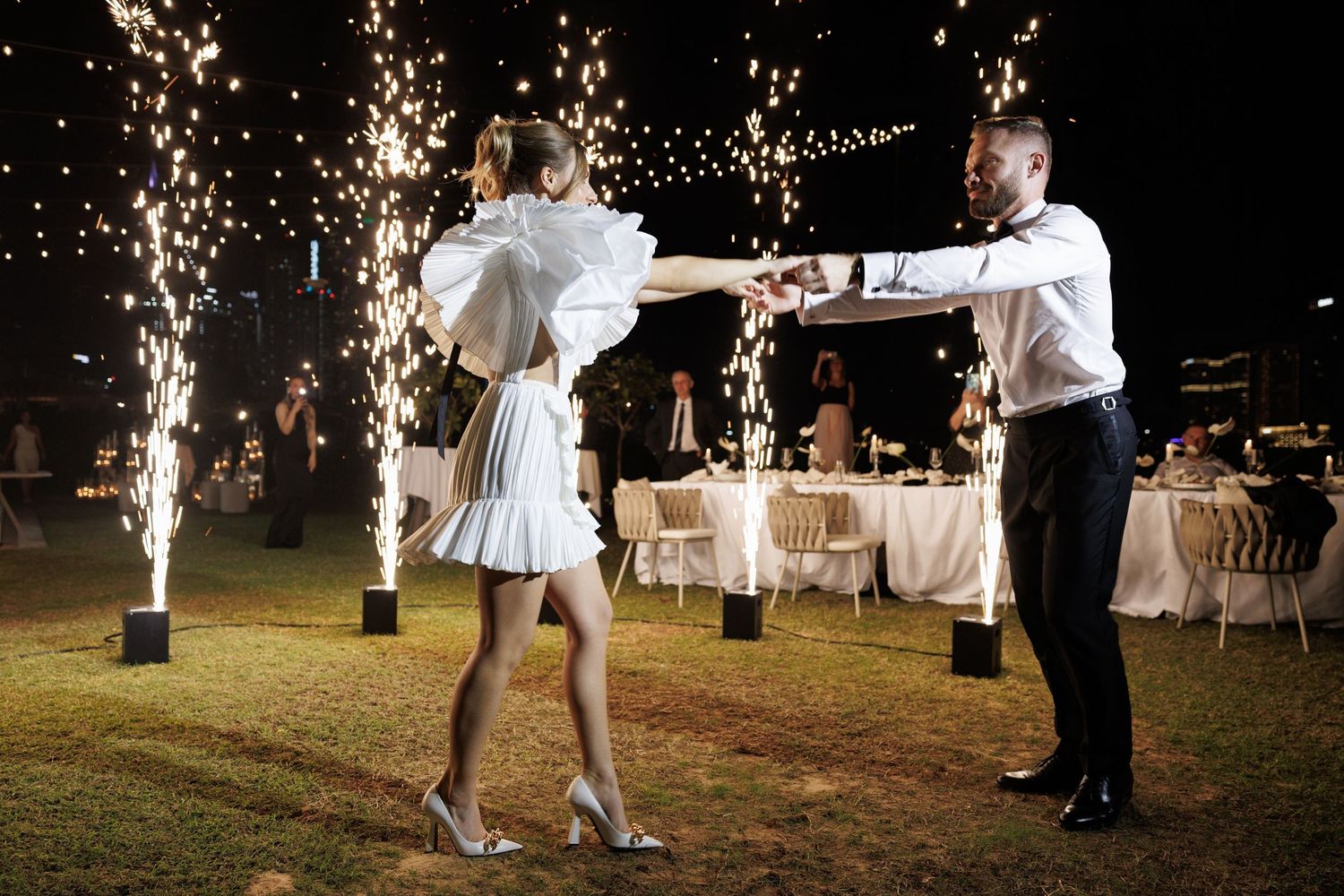 Wedding celebration with sparklers creating magical light trails at night.