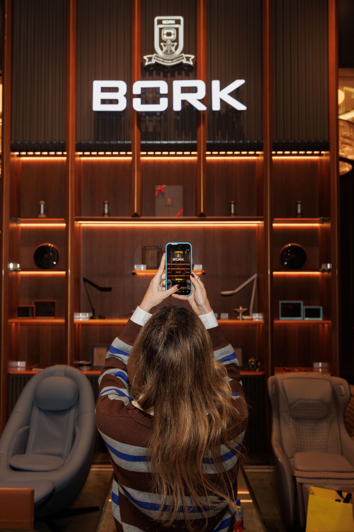 Interior view of a modern gaming lounge with illuminated BORK signage and blue accent lighting.