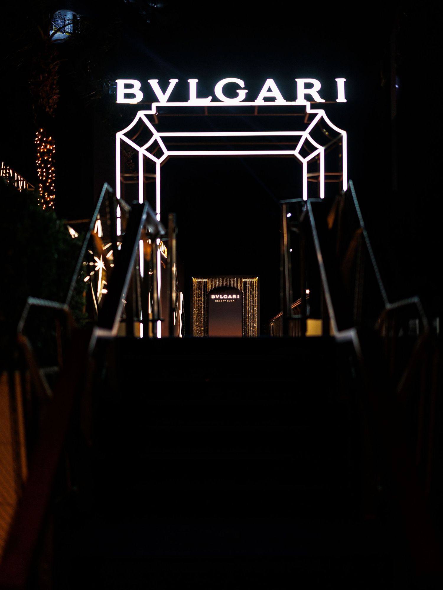 Illuminated Bulgari luxury brand logo displayed on dark background with geometric design elements and lighting effects.