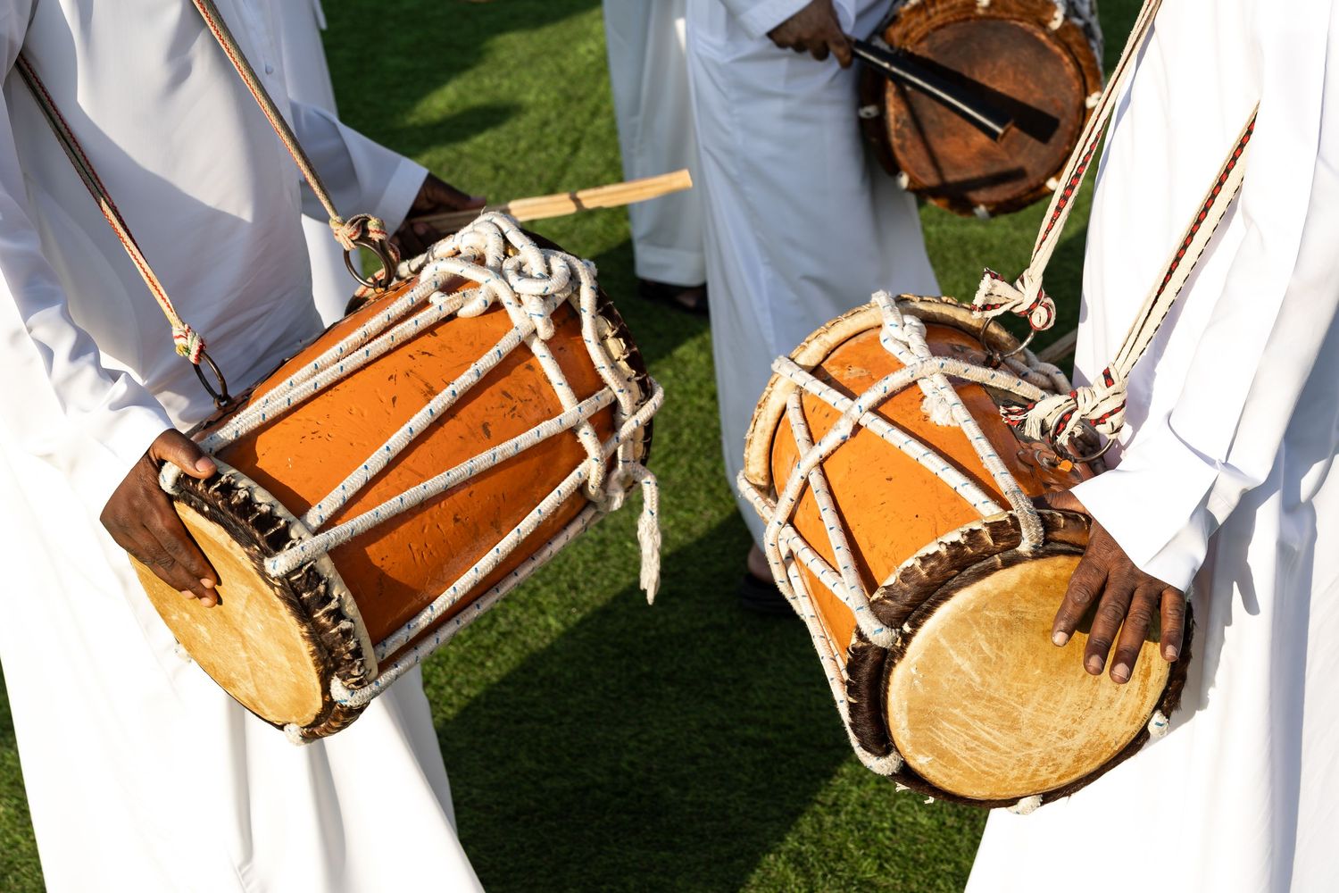 Traditional Korean drummers in white robes perform with traditional barrel drums during a cultural performance.