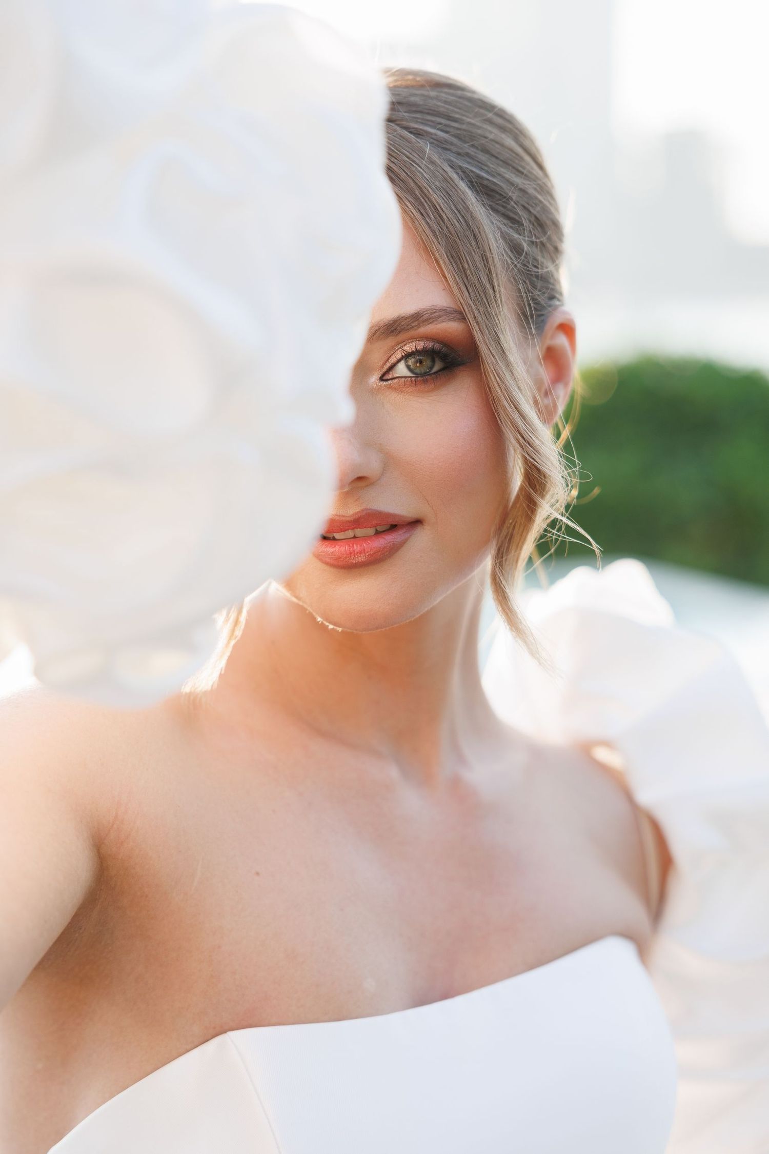 Artistic bridal portrait showing delicate details of makeup and wedding dress.