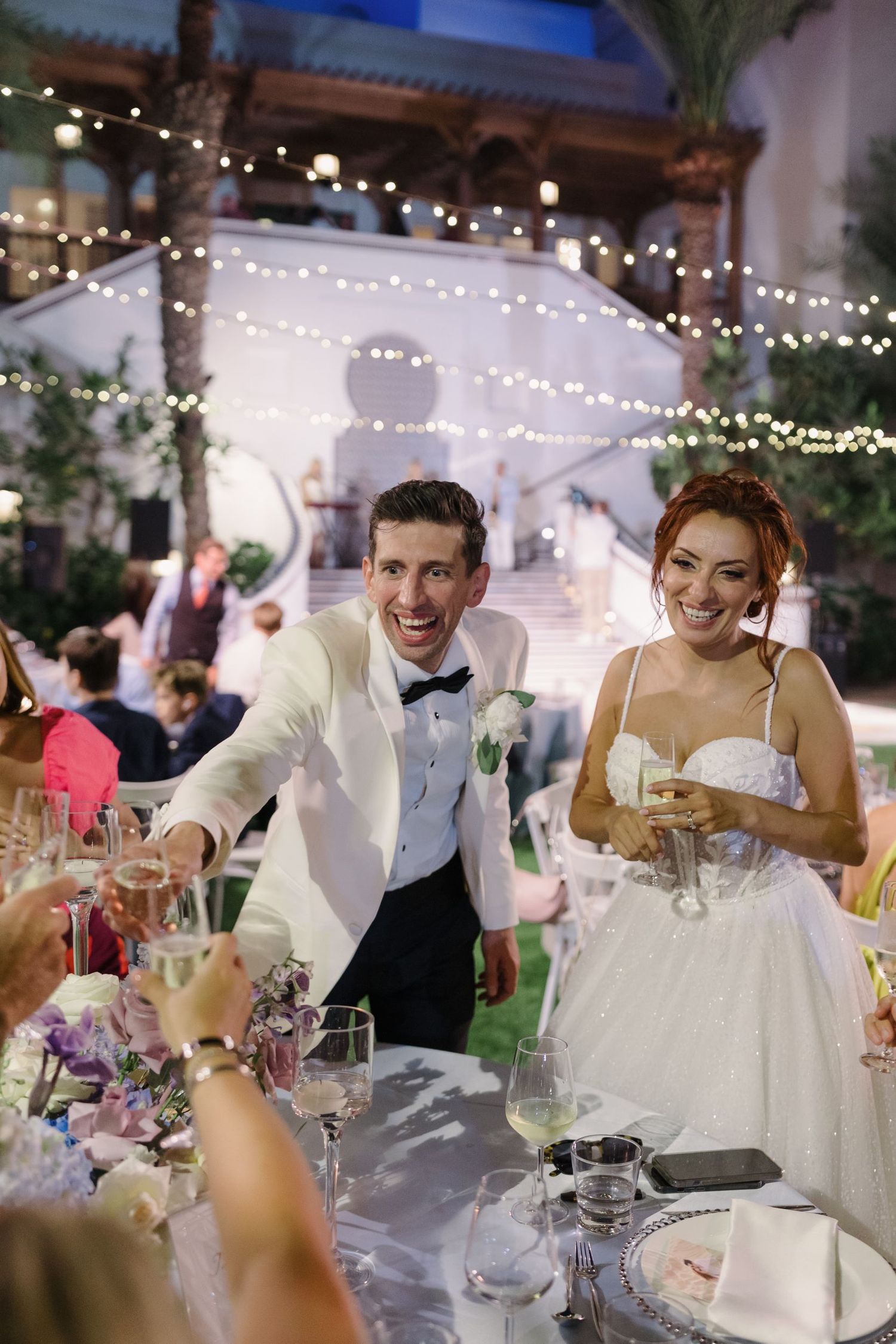 Newlyweds sharing a joyful moment with guests during their wedding reception.
