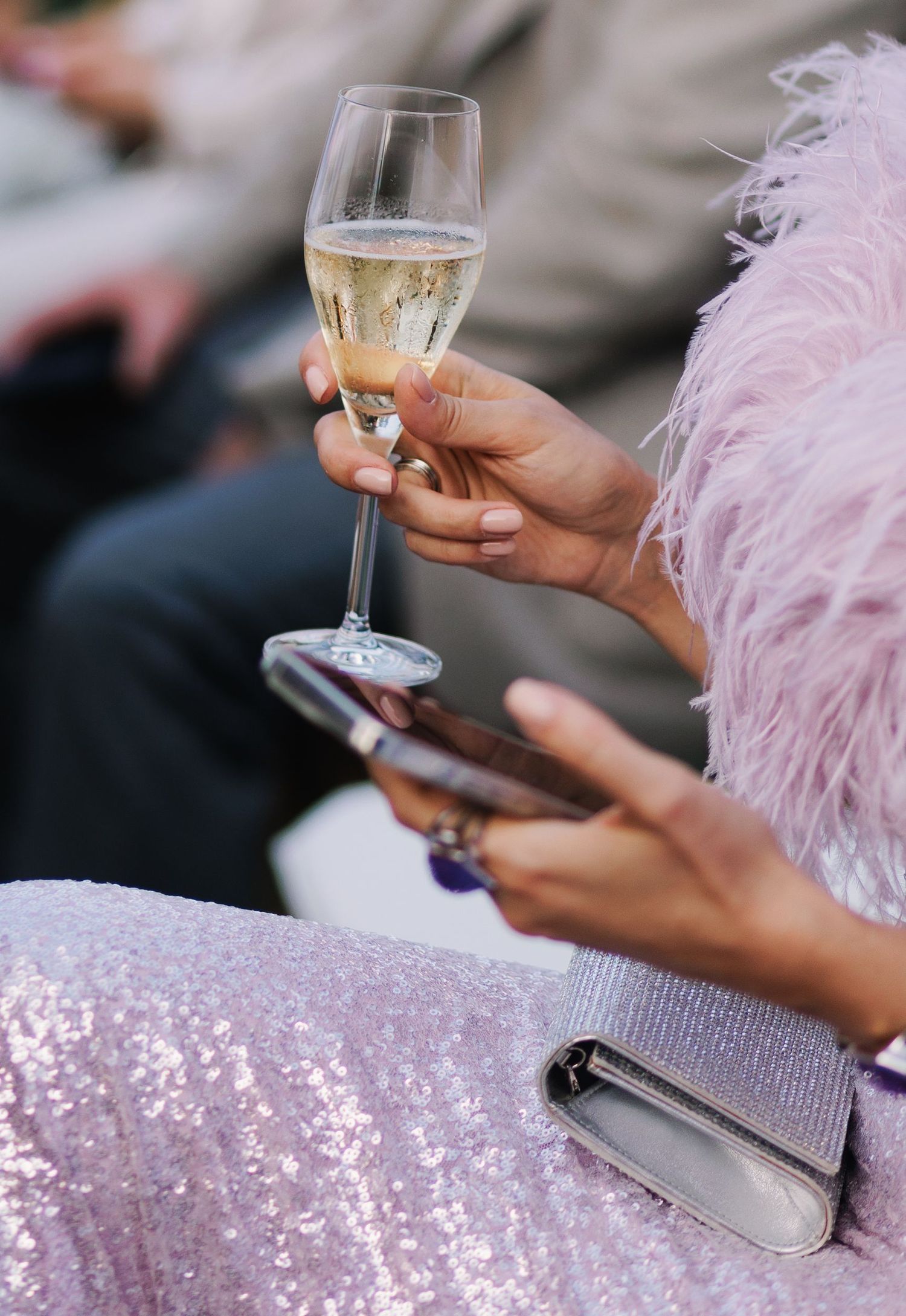 Close-up of champagne glasses and sparkly sequined details at an elegant event.