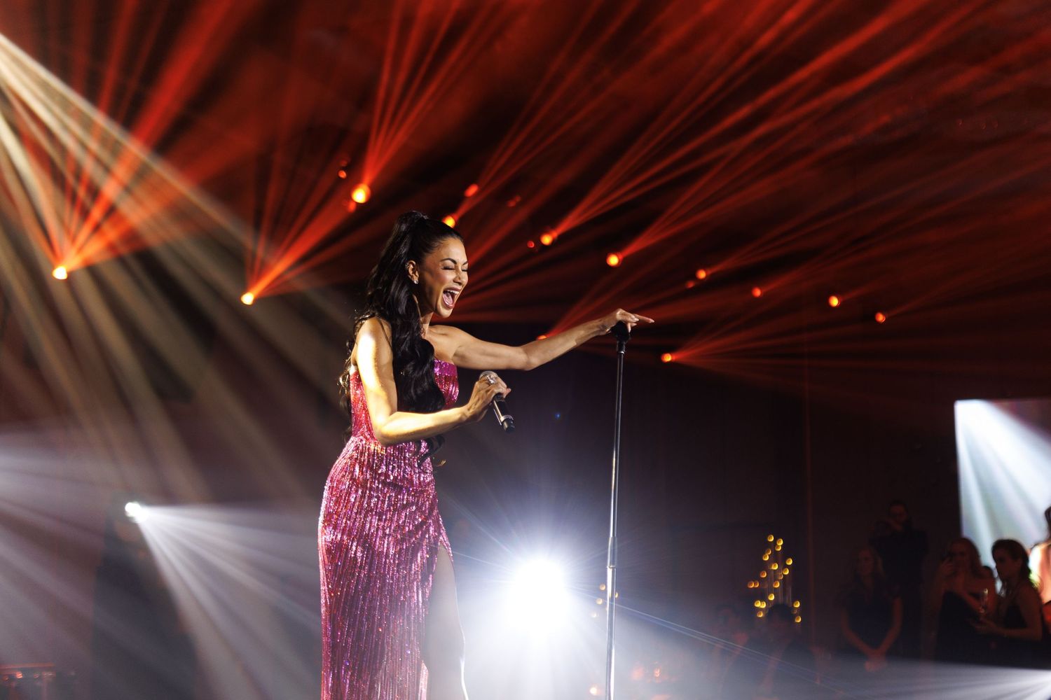 Performance stage with dramatic red lighting and beam effects during show.