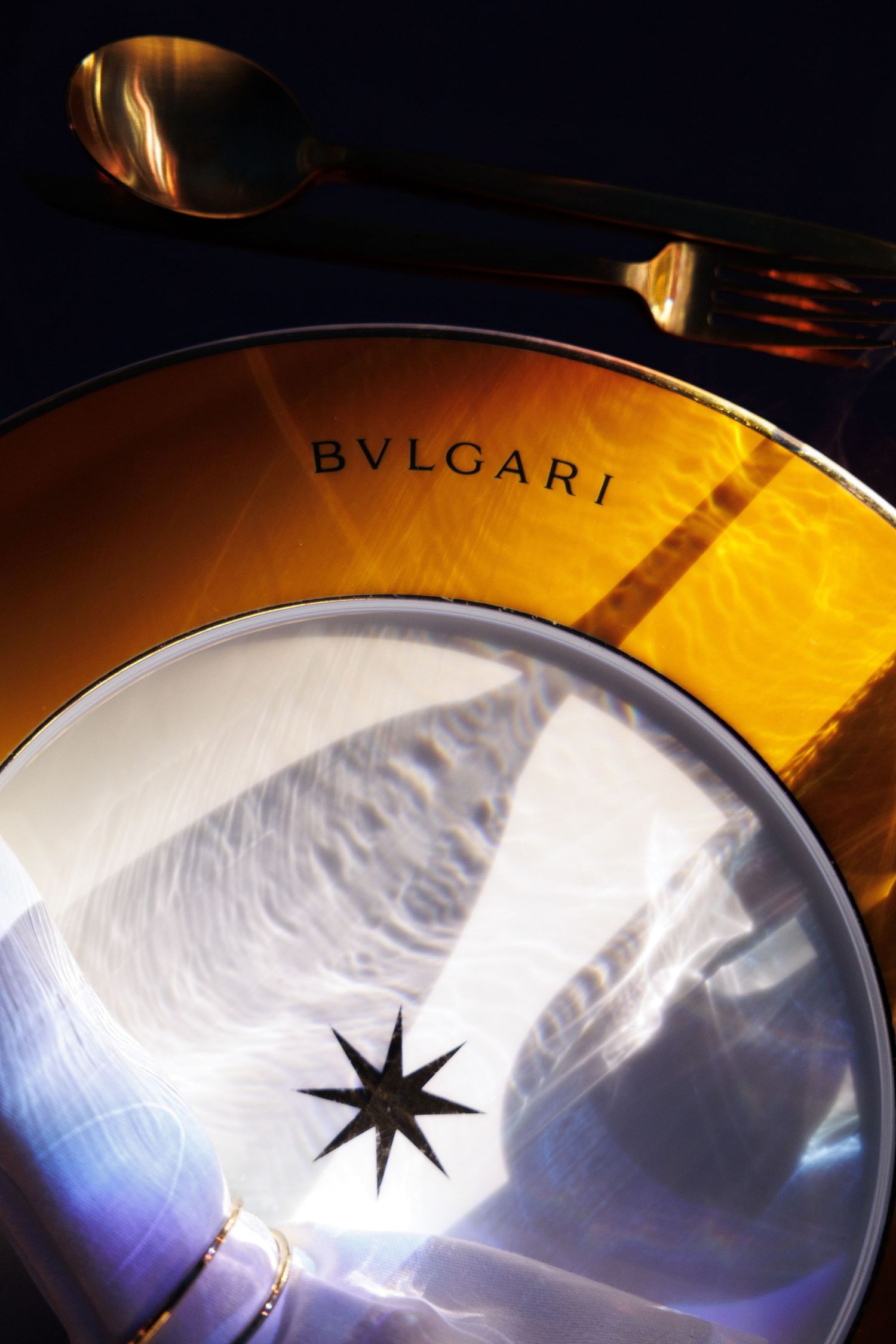 Close-up of a Bvlgari branded plate with artistic star pattern design.