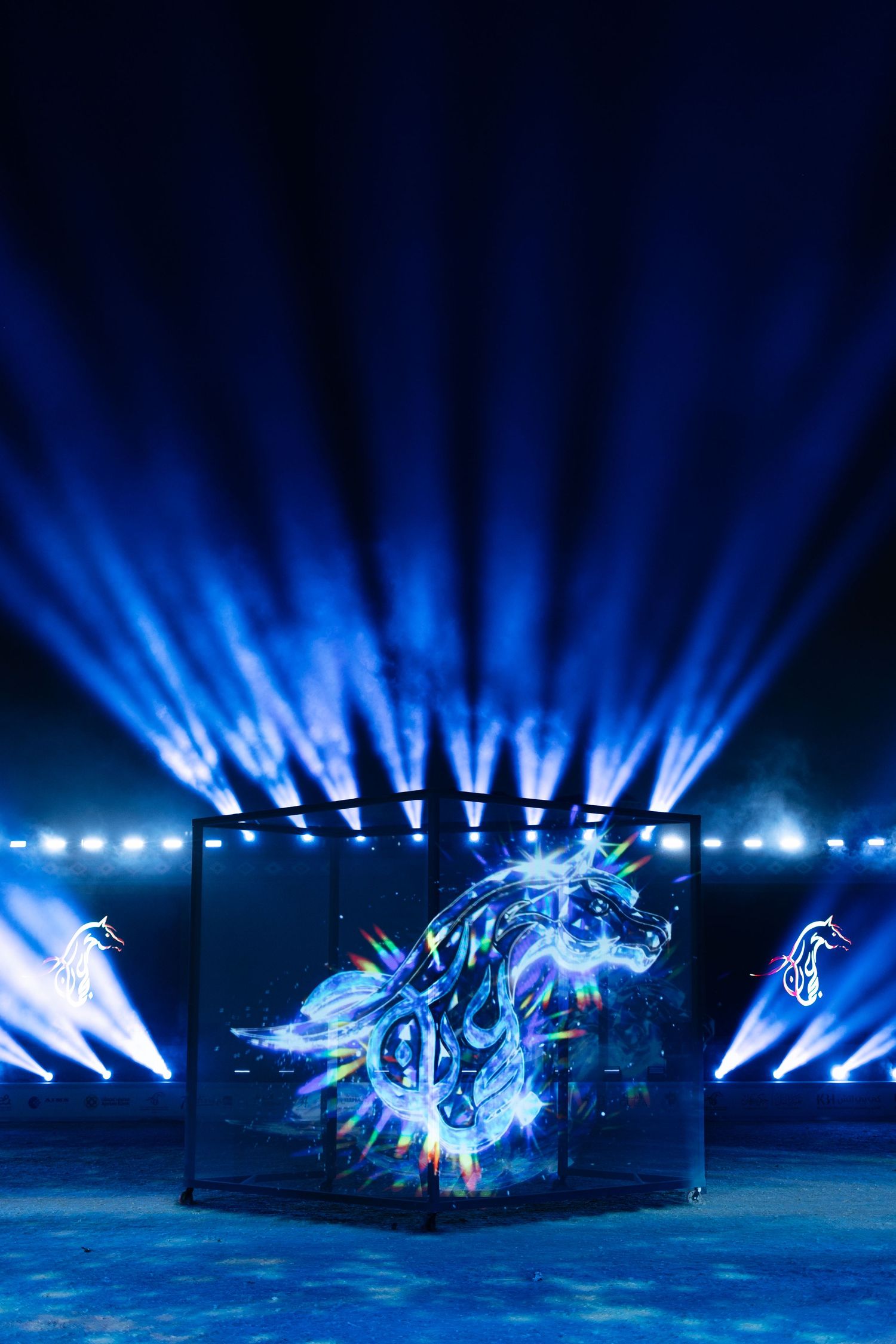 Dramatic blue light show with beams illuminating a dark stage in sequence across multiple frames.