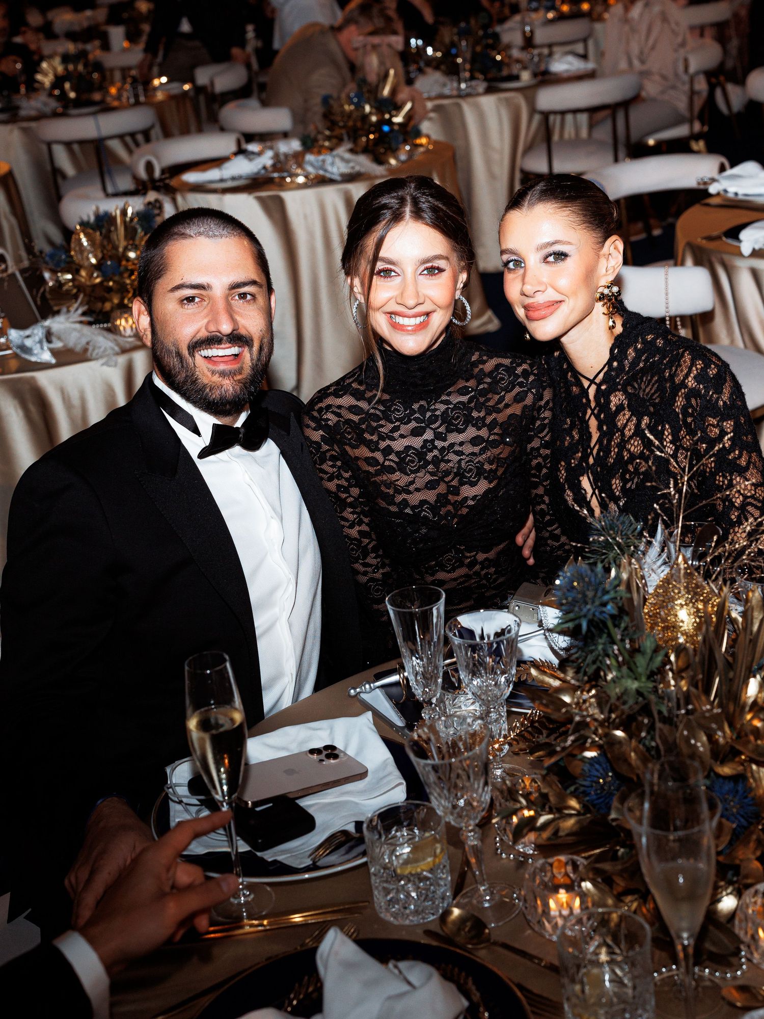 Guests enjoying a formal dinner event at an elegant table setting with crystal glasses and candlelight decor.