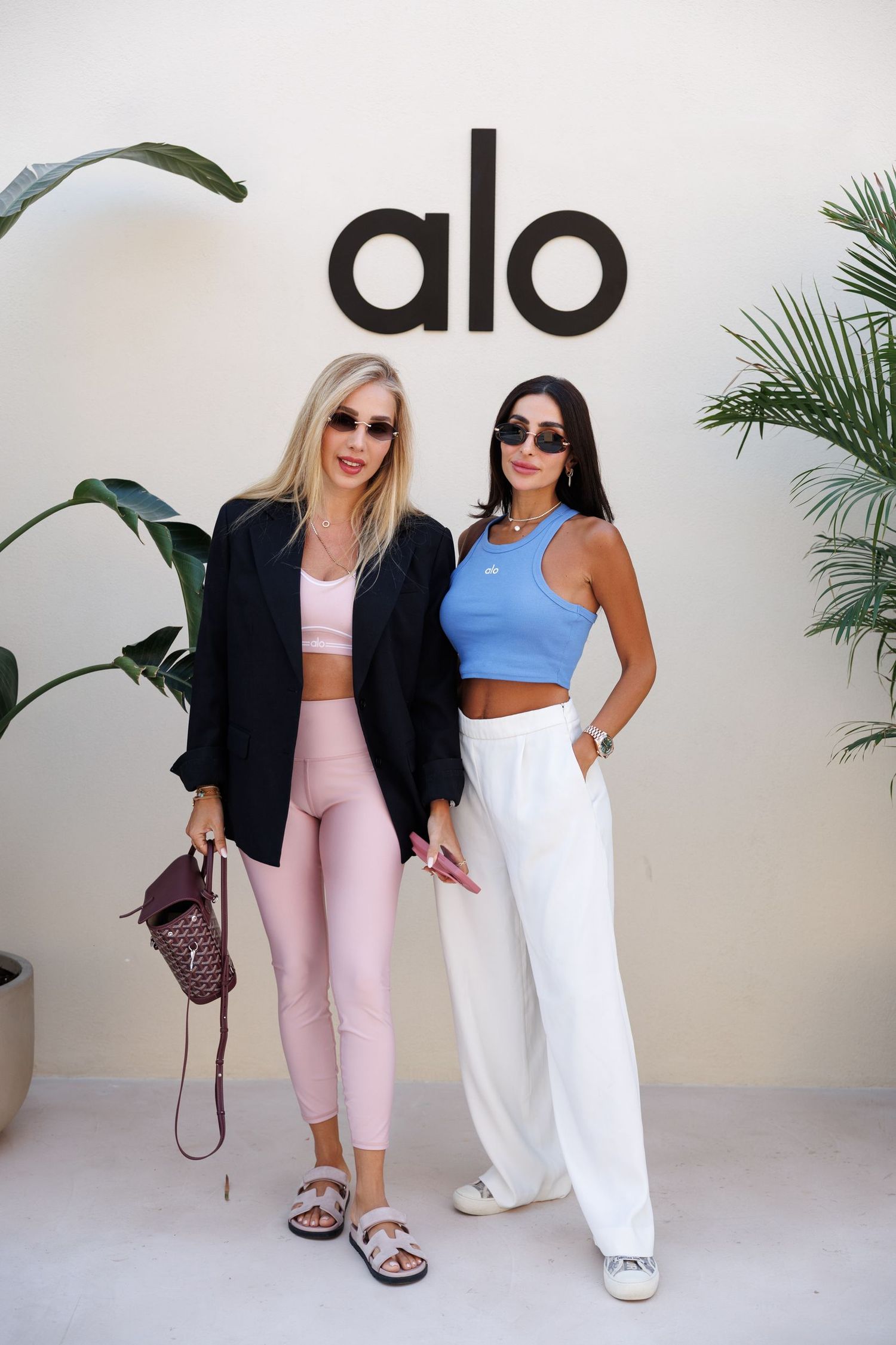 Models showcasing athletic wear collection in pink, white and black coordinated outfits.