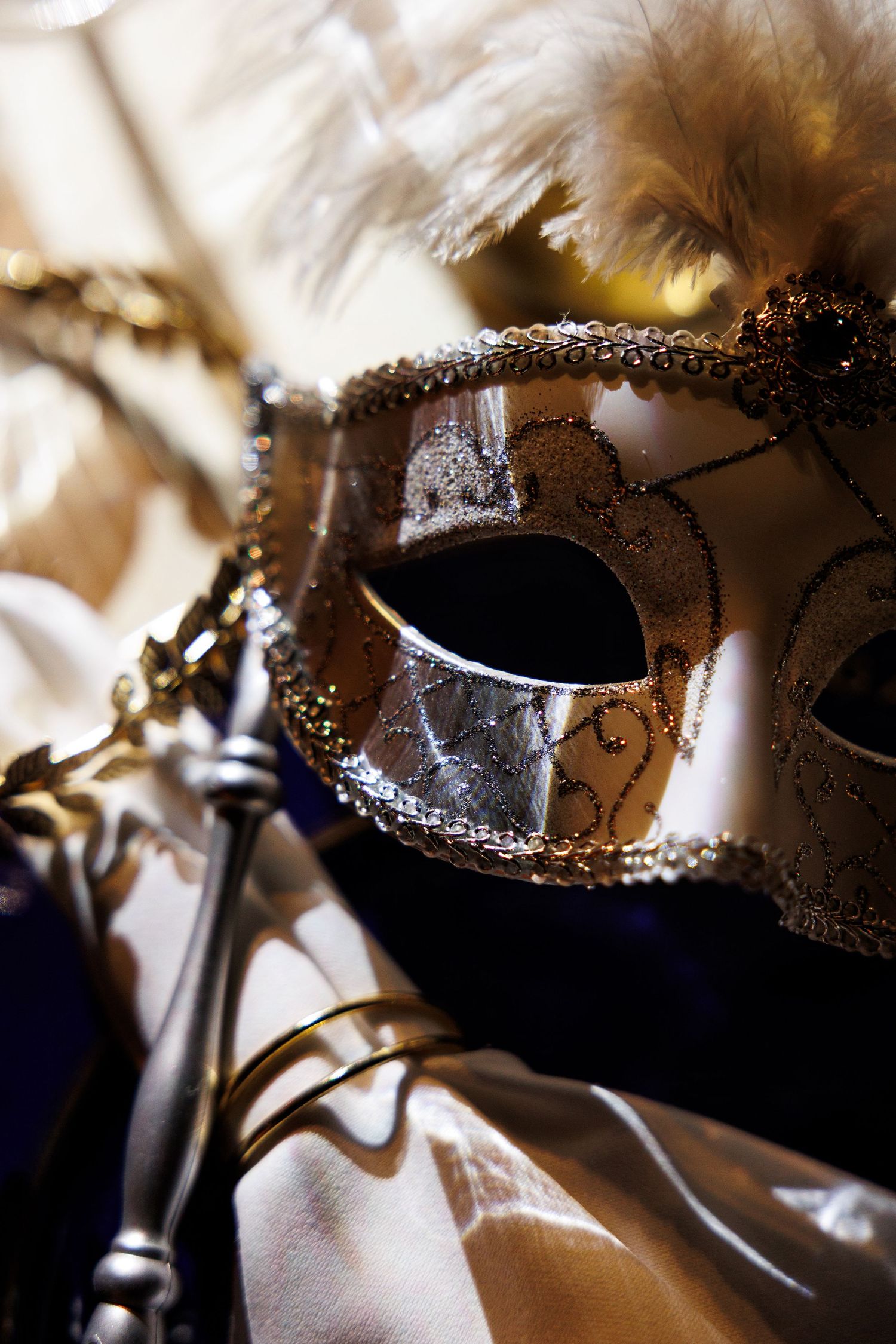 Ornate gold and brown masquerade masks with delicate beading and embellishments displayed in a row.