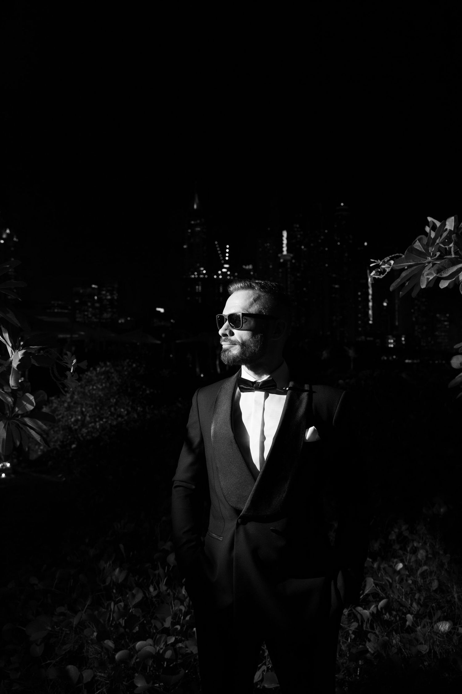 Elegant nighttime portrait showing formal attire against dark background.