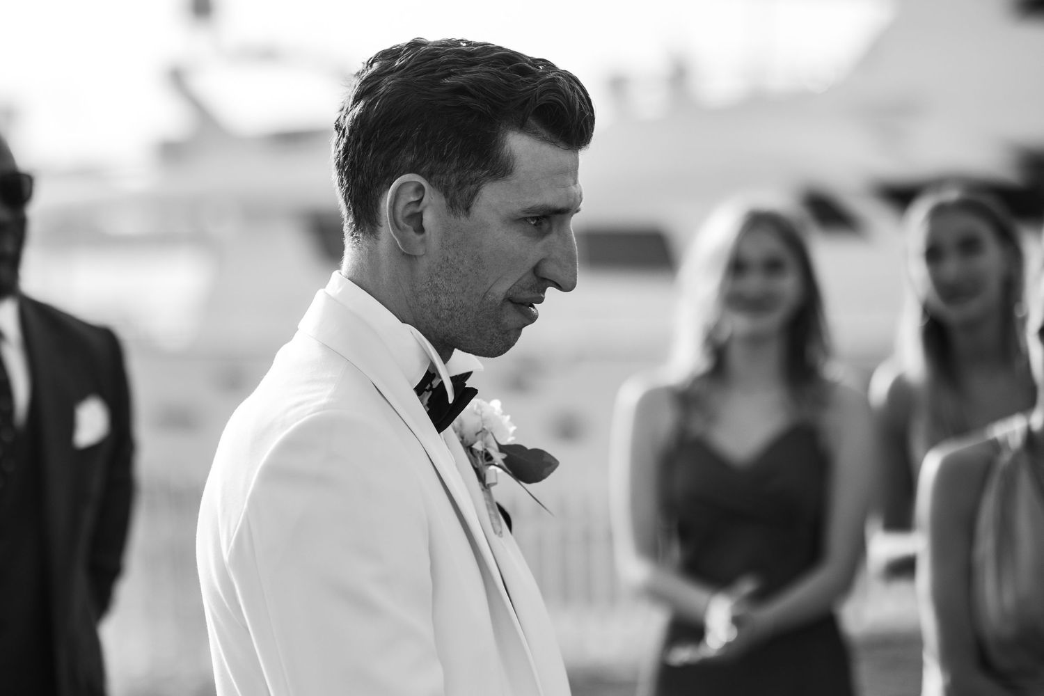 Wedding party members in formal attire during outdoor celebration.